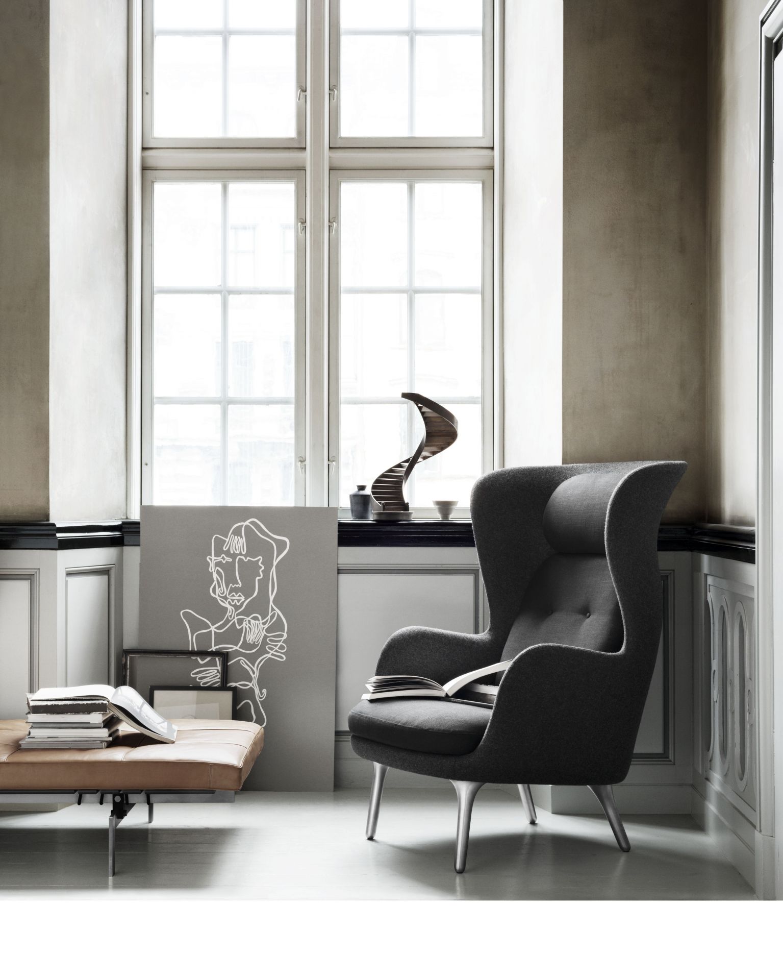 Grauer Ro Sessel von Fritz Hansen mit Buch in stilvollem Interieur, Design Möbel und Leseecke.
