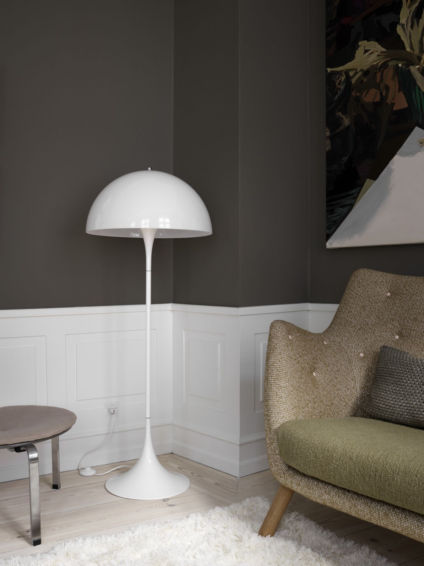 Moderne, weiße Stehlampe im Pilzdesign neben Sessel und Beistelltisch in stilvollem Wohnzimmer.