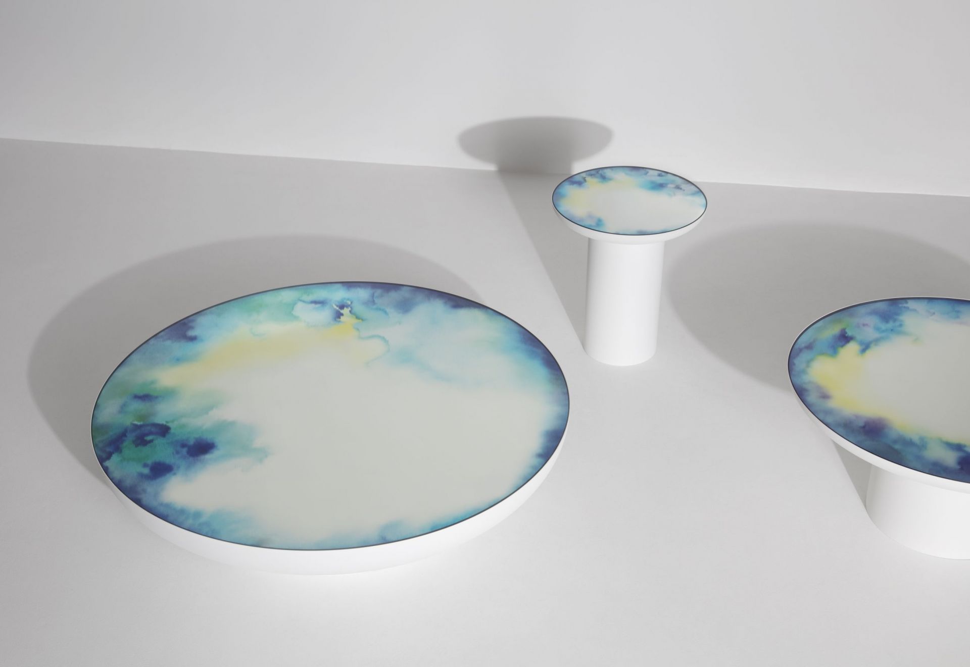 Weißer Francis Couchtisch von Petite Friture, runder Tisch mit blau-gelbem Muster auf der Tischplatte.