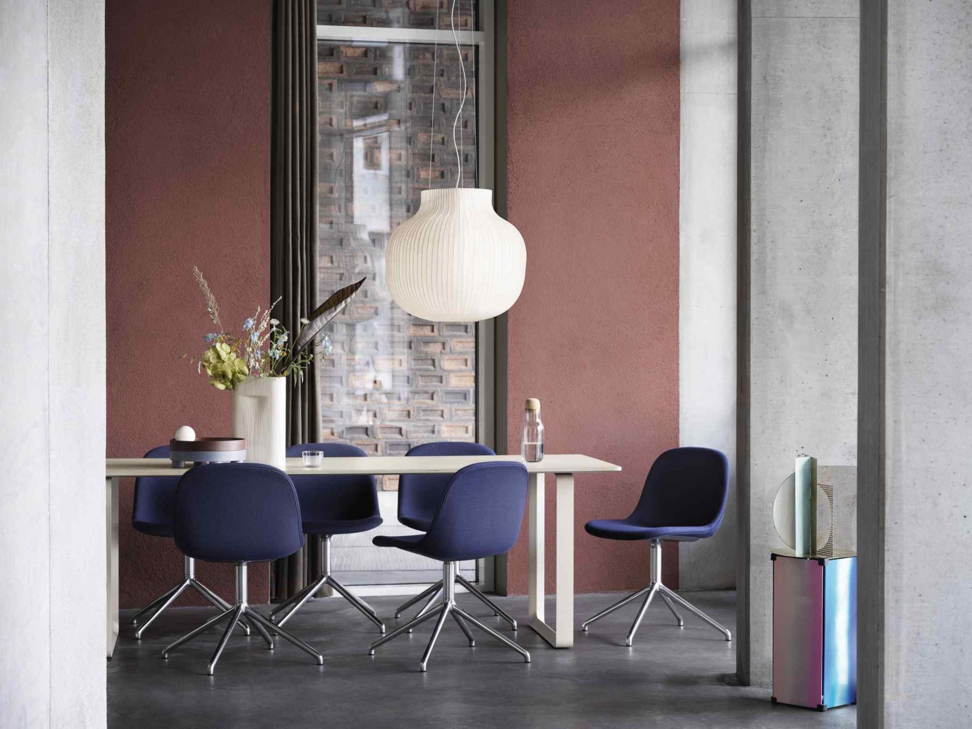 Esszimmer mit Esstisch, blauen Stühlen und der weißen Muuto Strand Pendant Lamp Pendelleuchte.