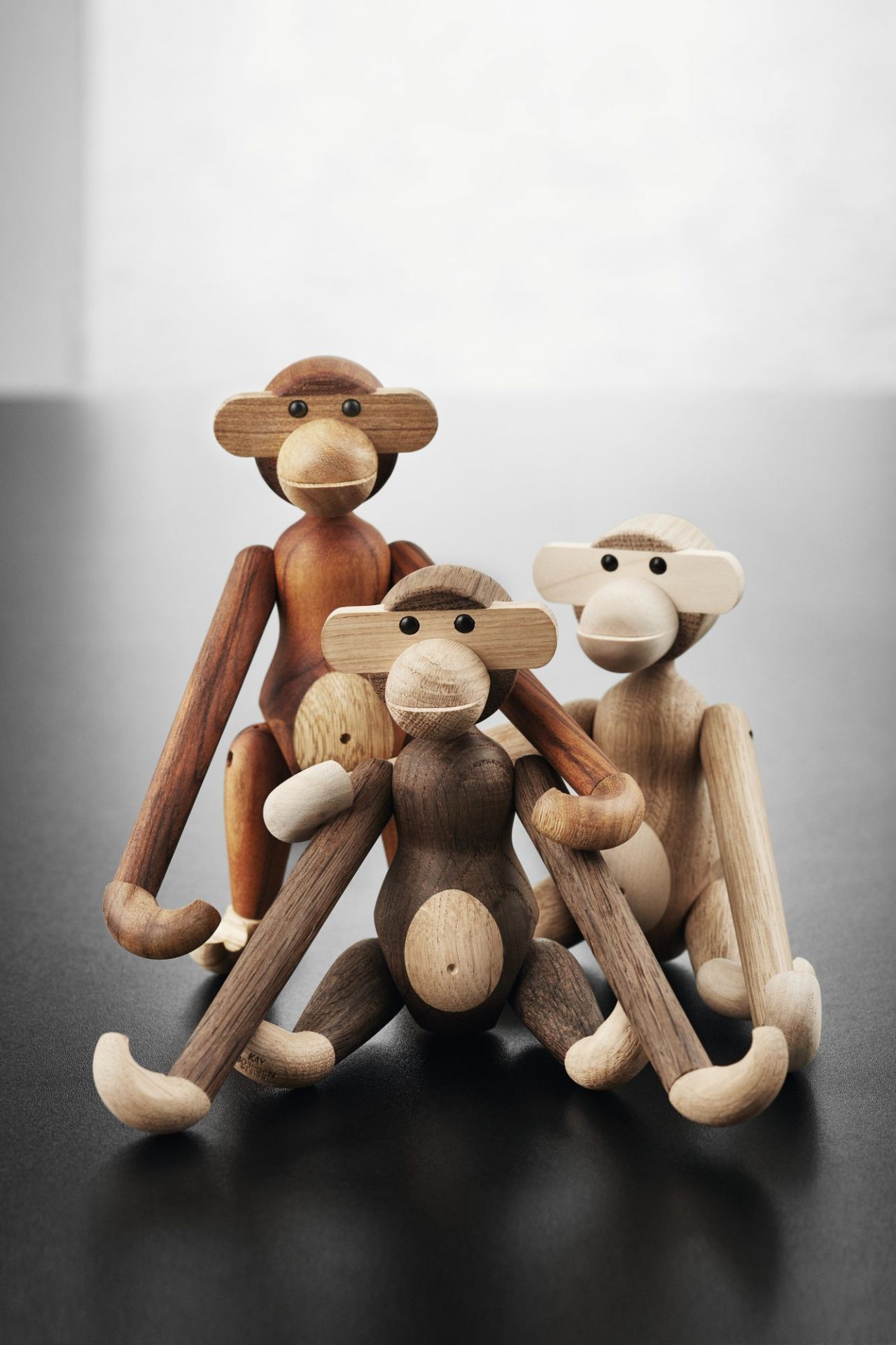 Drei Kay Bojesen Holzaffen in verschiedenen Farben, dekorative Holzfiguren für Kinderzimmer und Sammler.