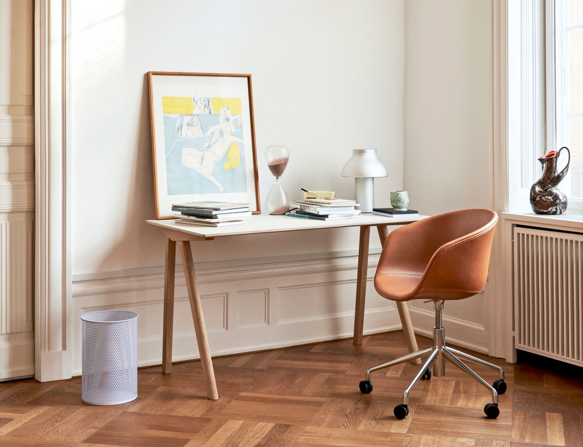 Heller Raum mit Copenhague Table CPH 90 Schreibtisch von Hay, Bürostuhl, Lampe und Dekoration auf Parkettboden.