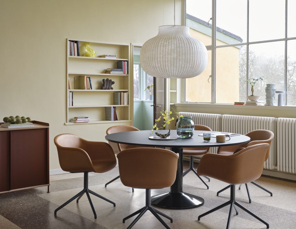 MIDST Table Esstisch von Muuto mit runder, schwarzer Tischplatte und braunen Stühlen in modernem Esszimmer.