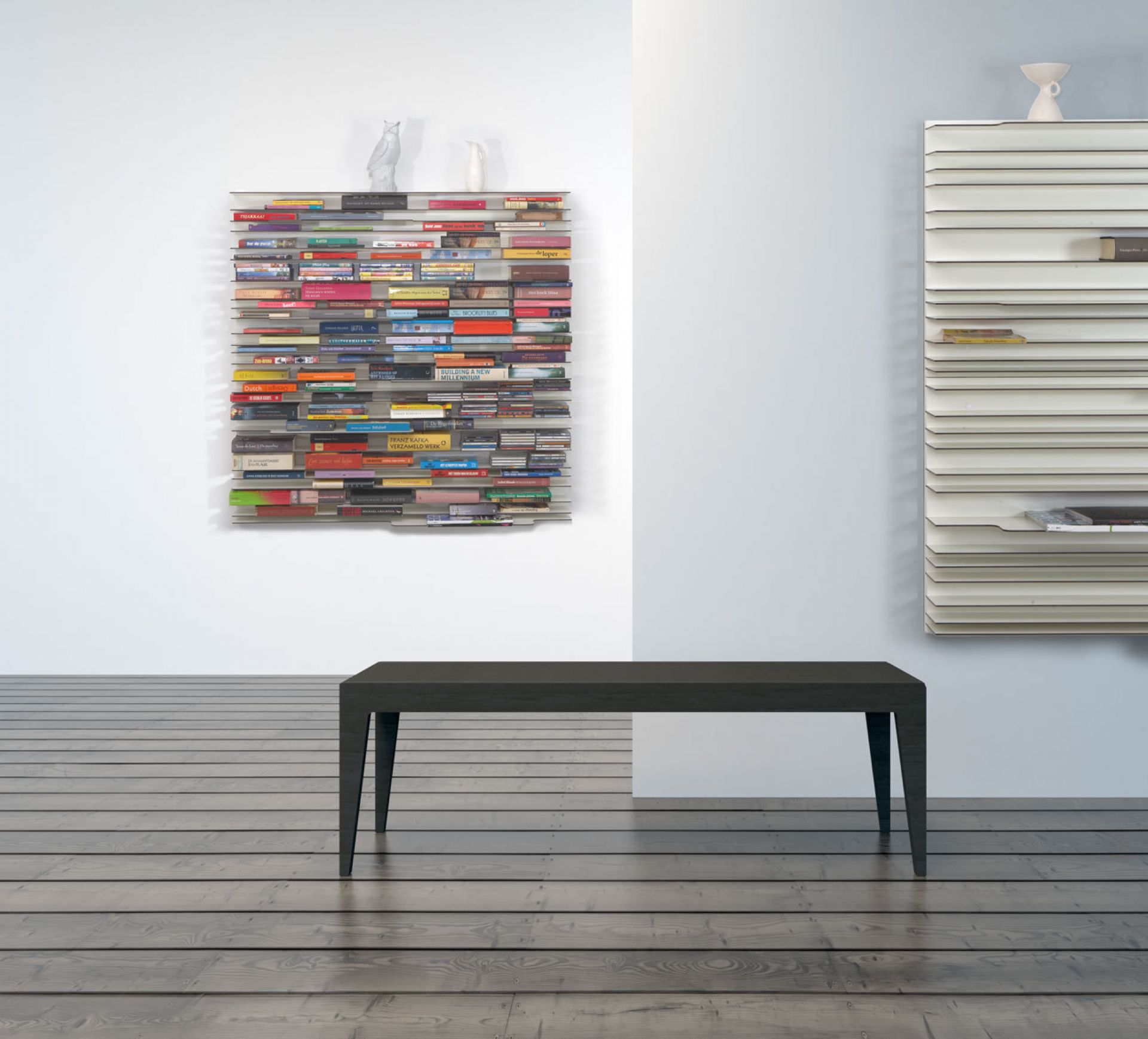 Modernes Paperback Bücherregal Spectrum an der Wand, gefüllt mit Büchern, im minimalistischen Wohnzimmer.