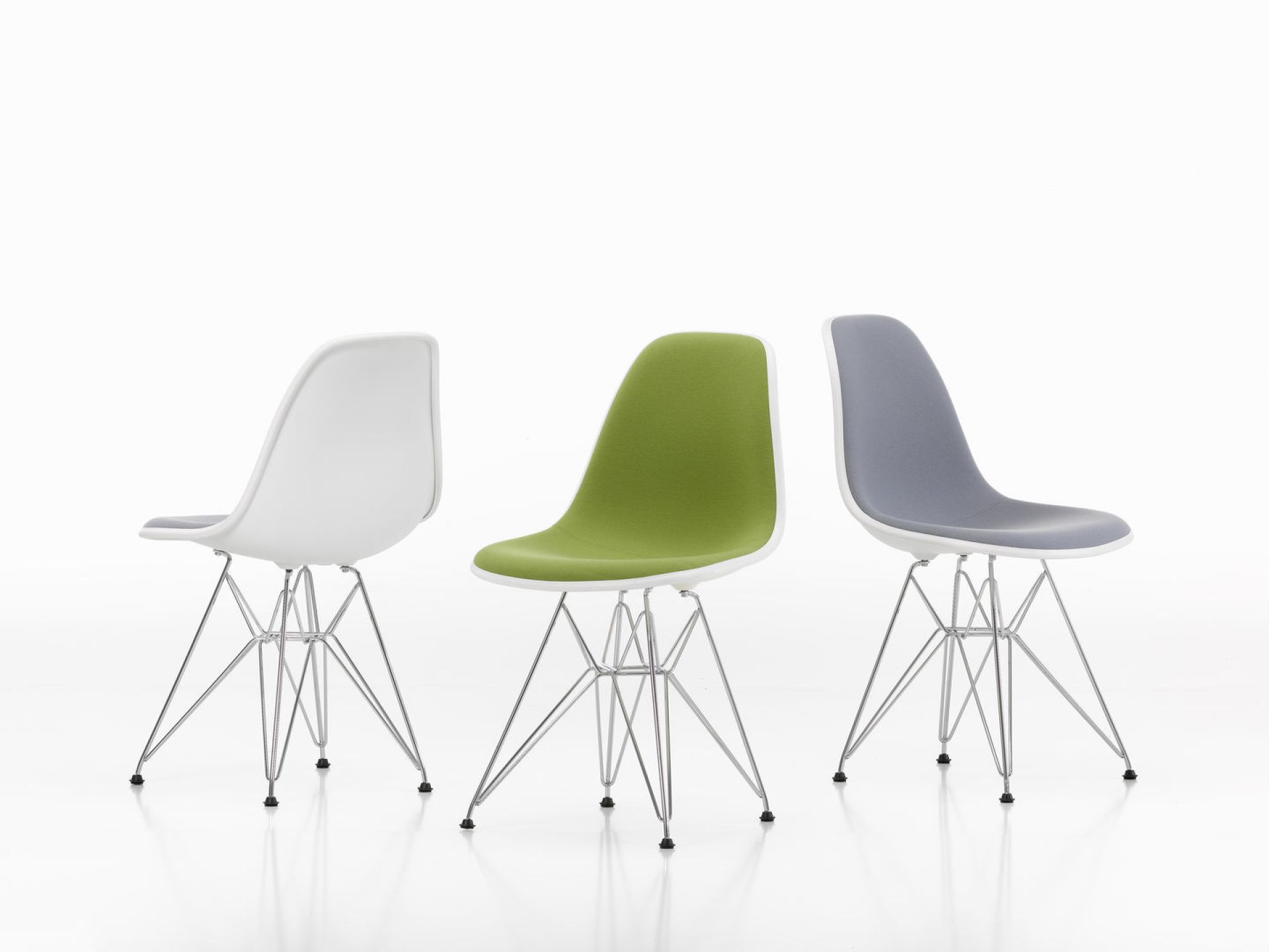 Drei Eames Plastic Side Chairs DSR von Vitra in Weiß, Grün und Grau mit Chromgestell.