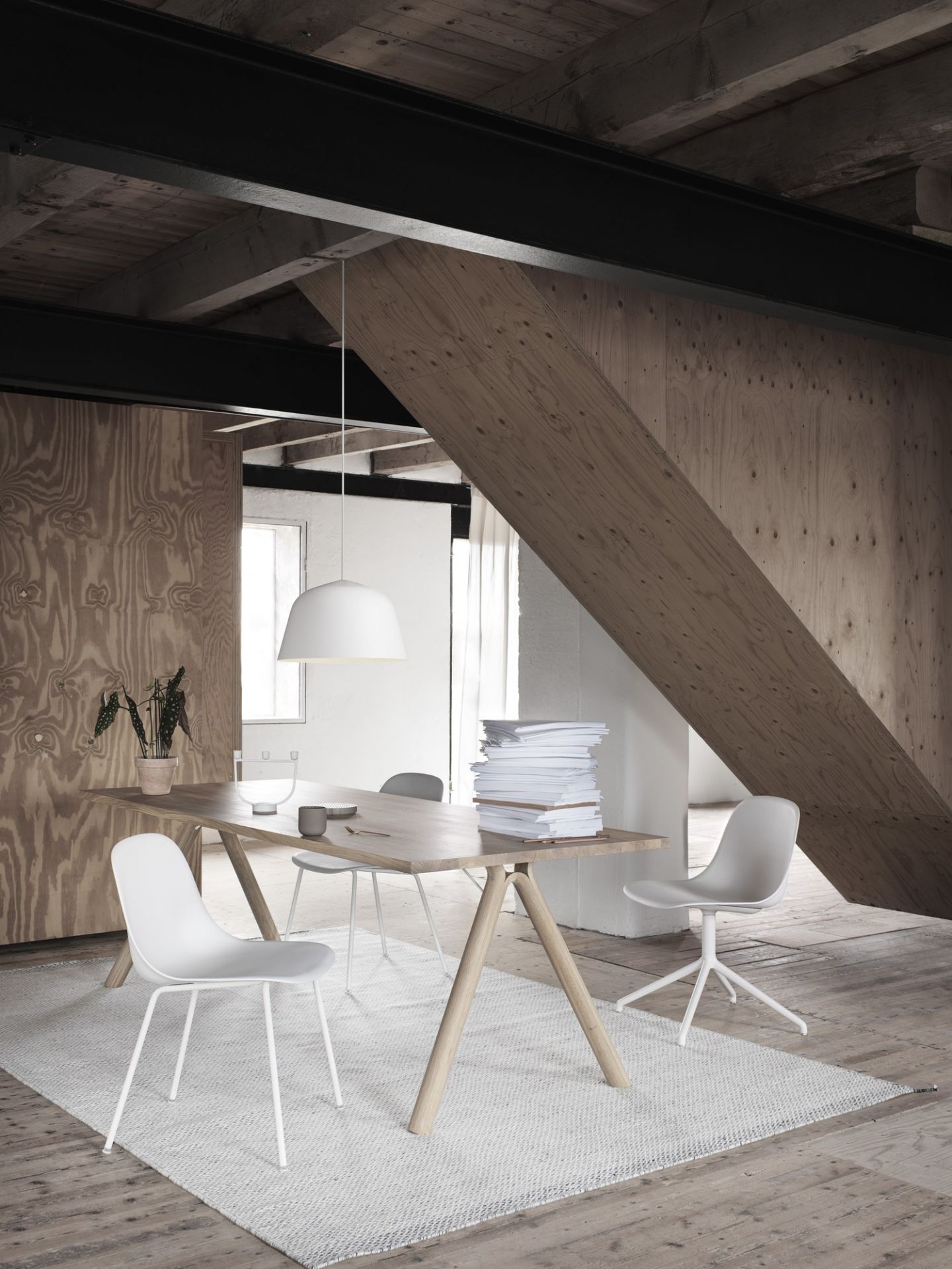 Helle Ambit Pendelleuchte von Muuto über Esstisch mit Stühlen in modernem, hellem Raum.