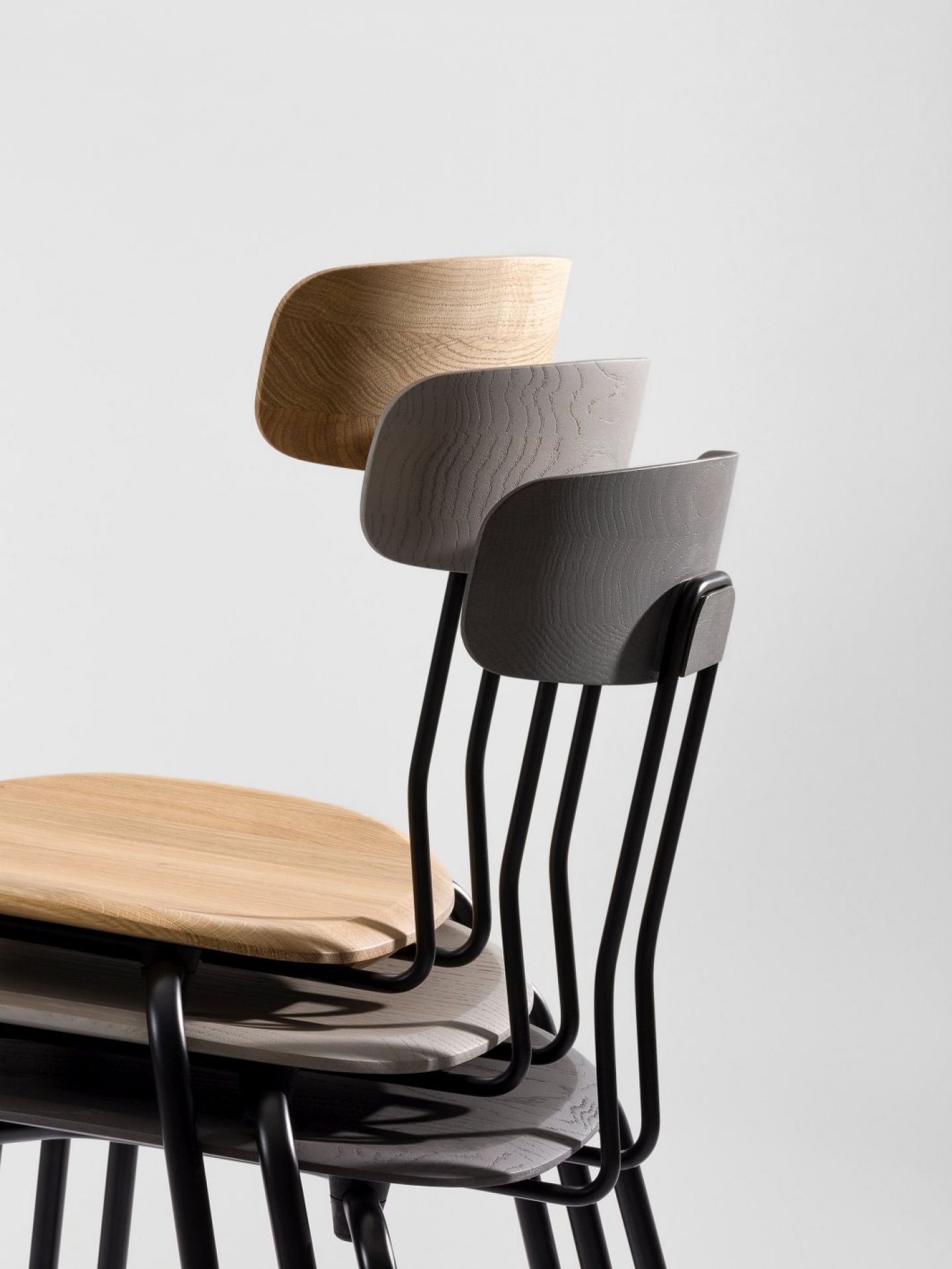 Okito Chair Stühle in Holzfarben gestapelt, modernes Design mit schwarzem Metallgestell für Esszimmer.