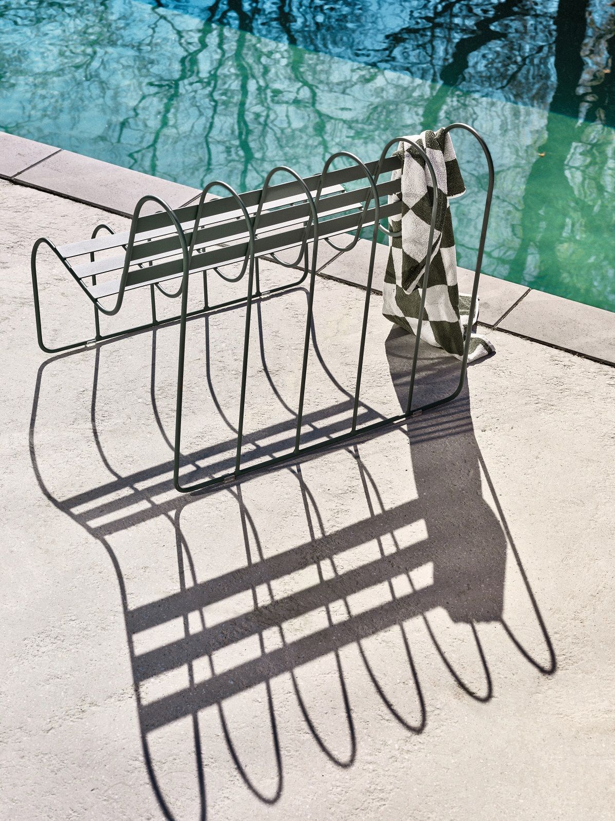 Gardener's Sofa von Design House Stockholm aus grünem Metall am Pool mit Handtuch.
