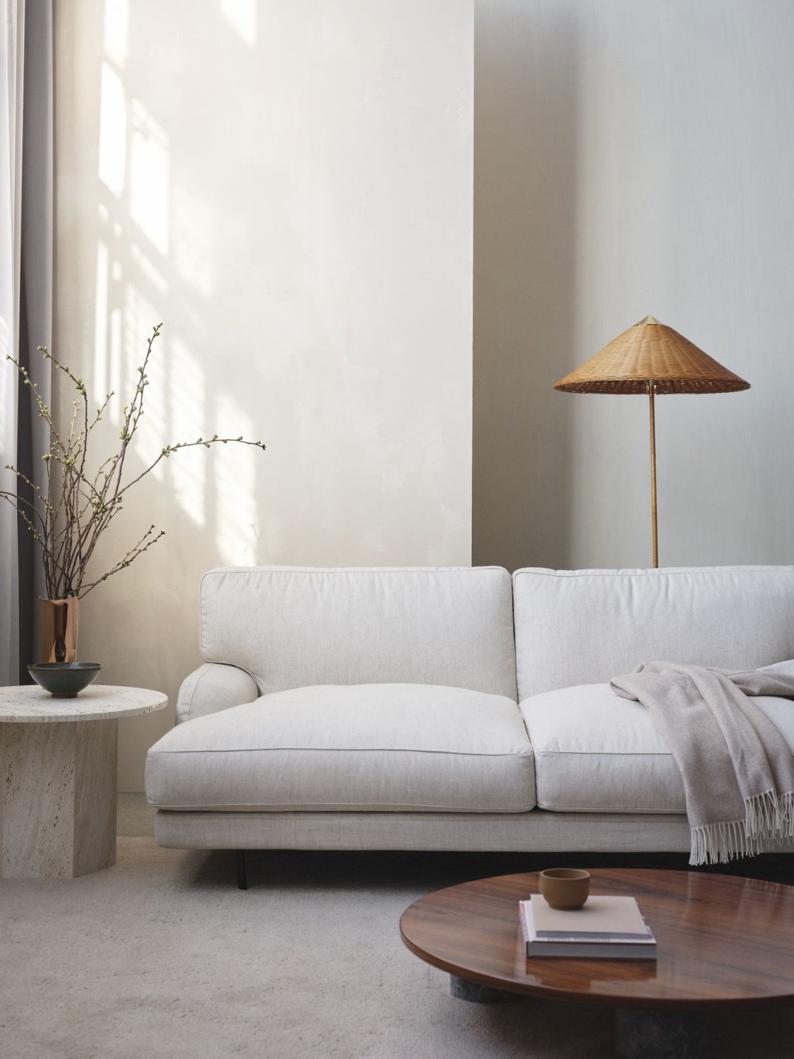 Helle Wohnzimmer-Szene mit Gubi 9602 Stehleuchte aus Weide, stilvolle Beleuchtung und gemütliches Ambiente.
