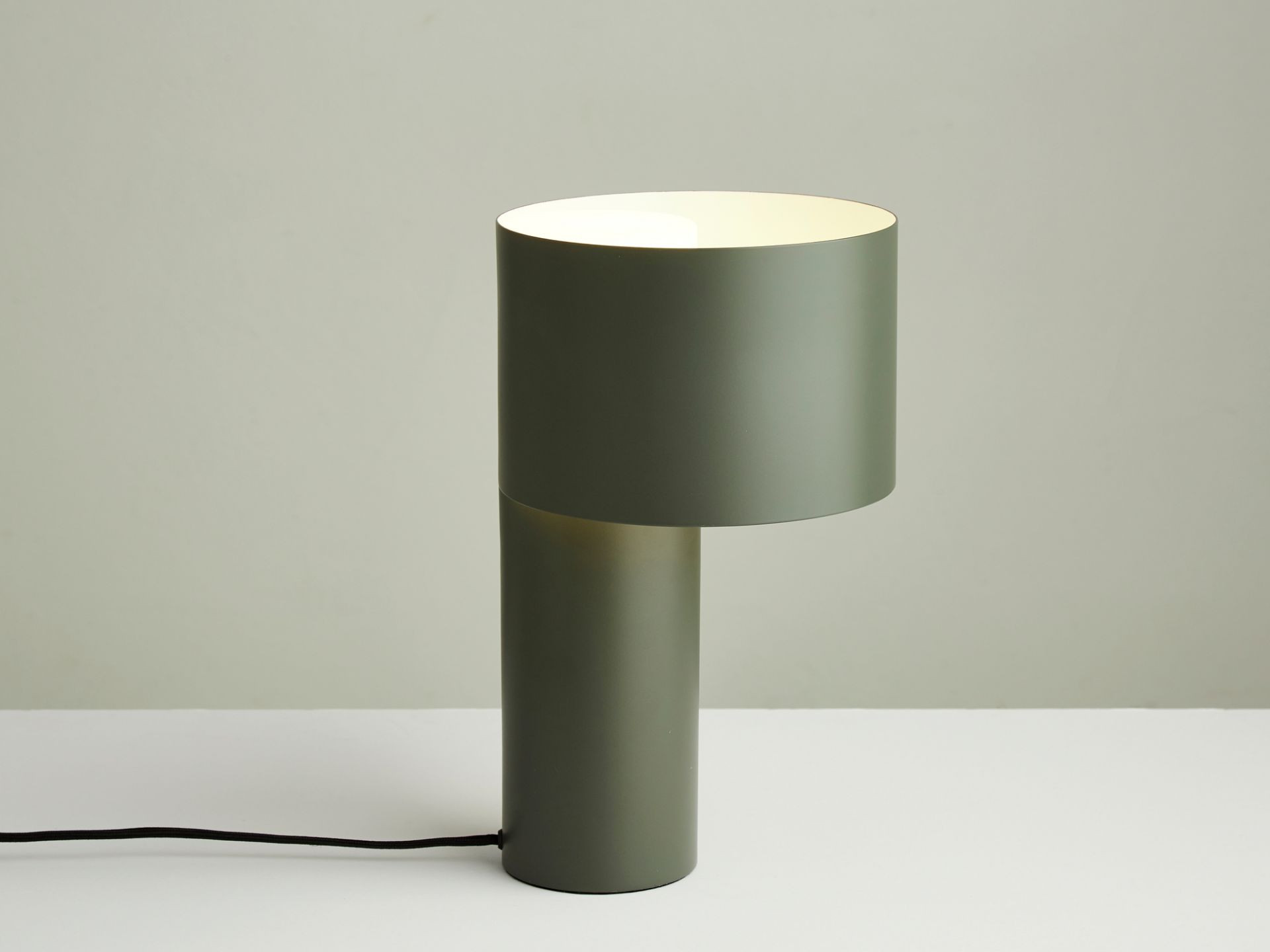 Grüne Tangent Tischleuchte von Woud, moderne Nachttischlampe mit zylindrischem Lampenschirm und warmem Licht.