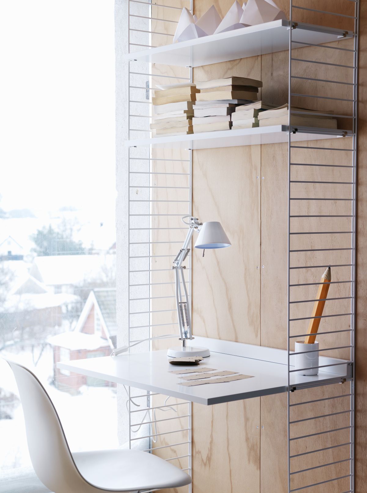 String Furniture Schreibtischplatte, Teil eines Regalsystems. Moderner Arbeitsplatz mit Lampe und Zubehör.
