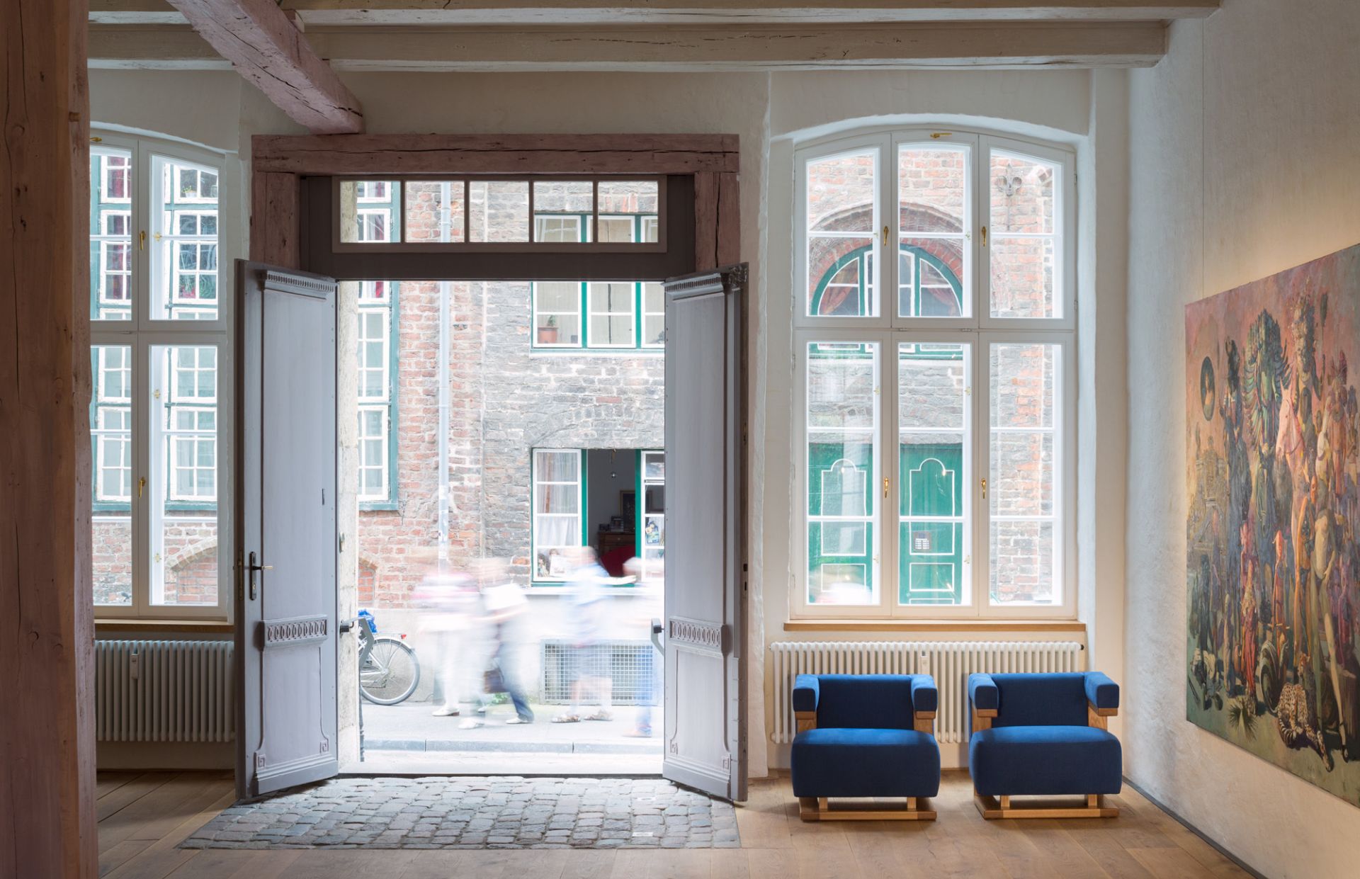 Zwei blaue Gropius F51 Sessel Bauhaus Reedition Tecta vor geöffneter Tür in historischem Gebäude.