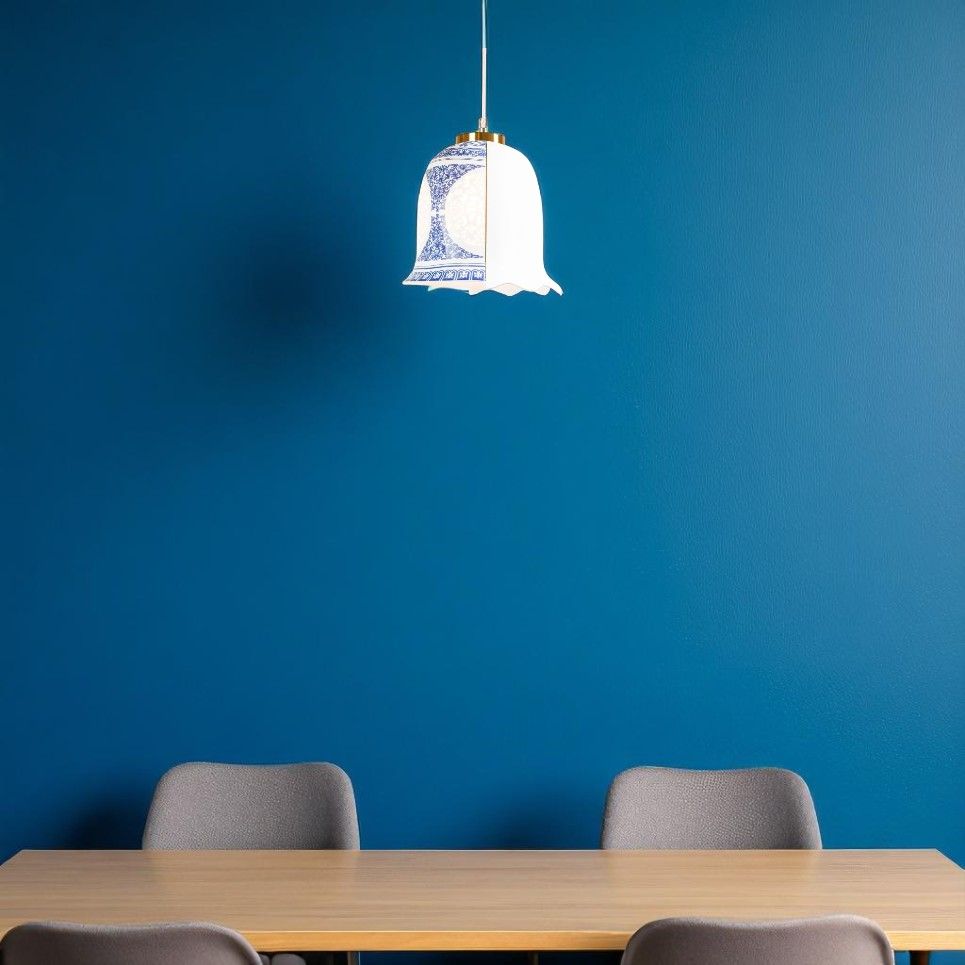 Seletti Hybrid Lauvia Deckenleuchte über Esstisch mit grauen Stühlen vor blauer Wand.