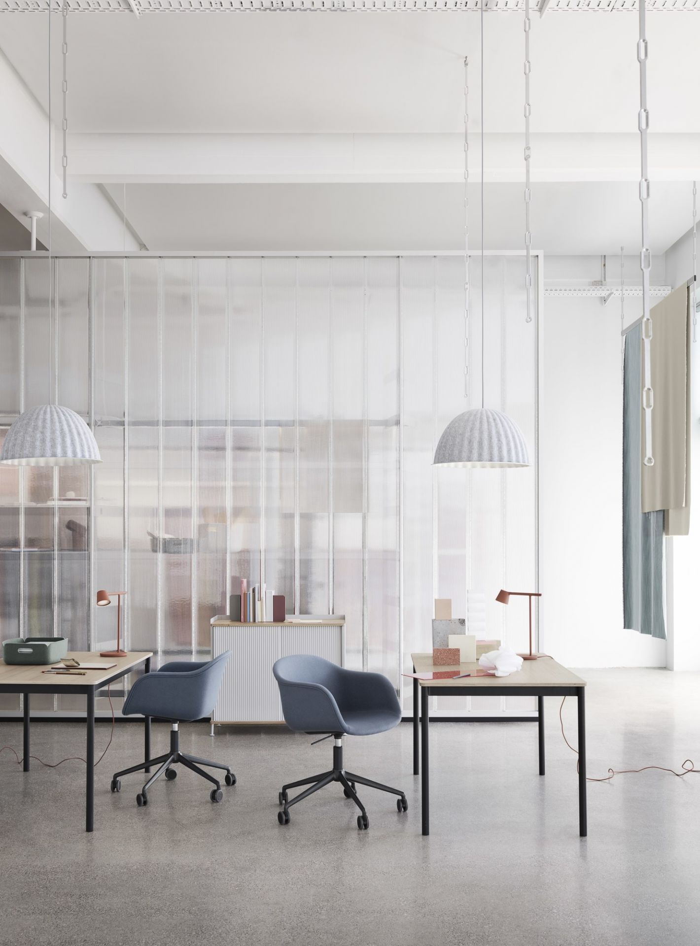 Helle Büroeinrichtung mit zwei Under The Bell Pendelleuchten von Muuto und modernen Büromöbeln.