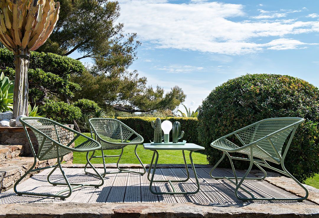 Grüne Sixties Outdoor Möbel: Niedriger Tisch und Sessel von Fermob im Garten.