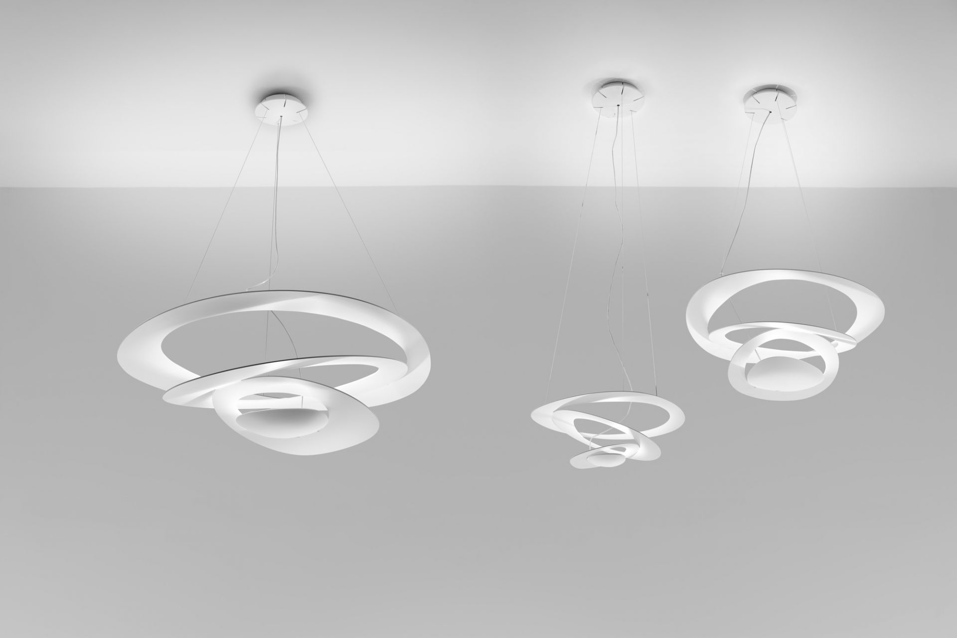 Weiße Pirce Mini Pendelleuchten von Artemide: Moderne Hängelampen mit geschwungenen Formen für Wohnzimmer und Esszimmer.