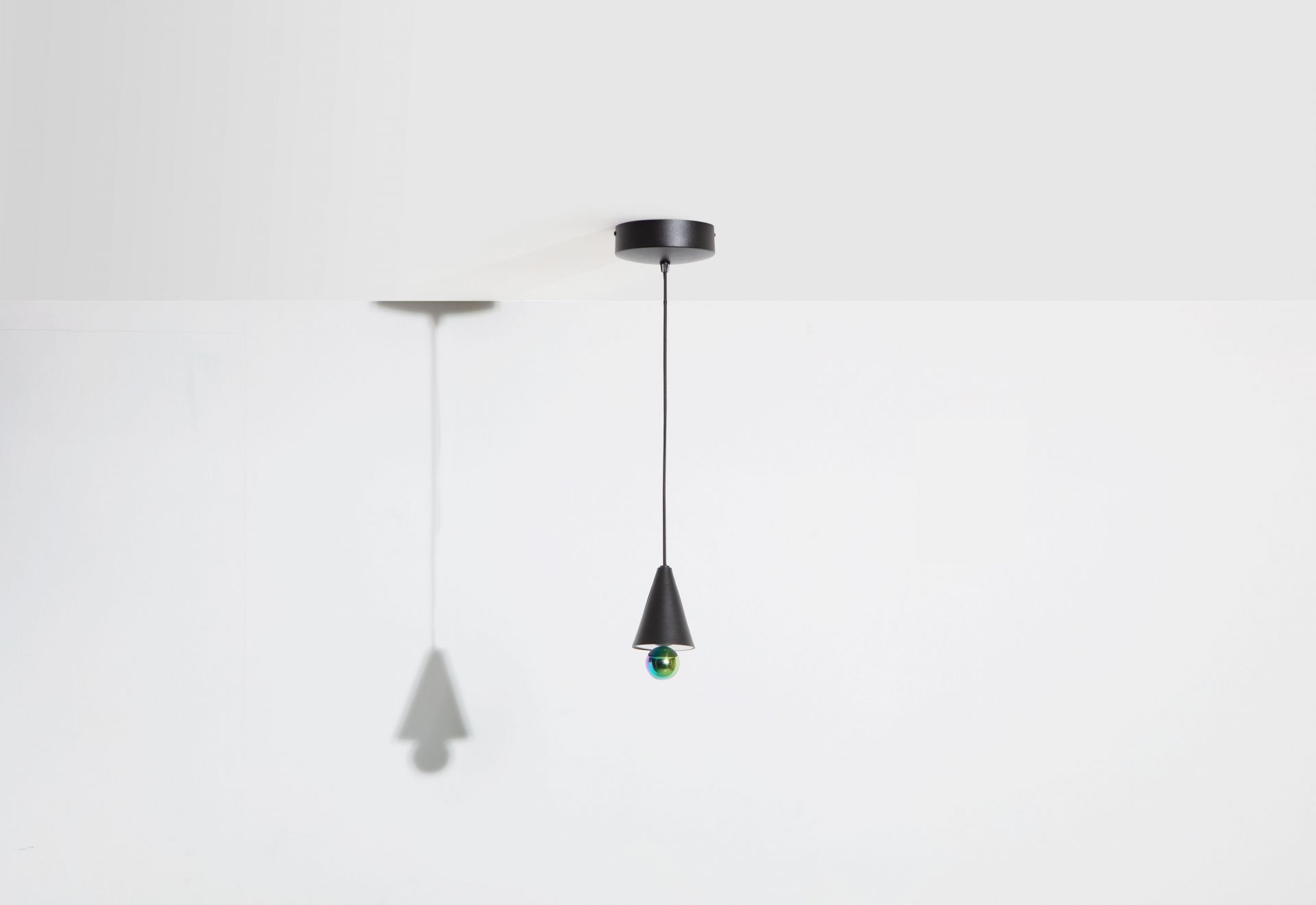 Schwarze Cherry Pendelleuchte von Petite Friture mit schimmernder Kugel und Kegelform vor weißem Hintergrund.