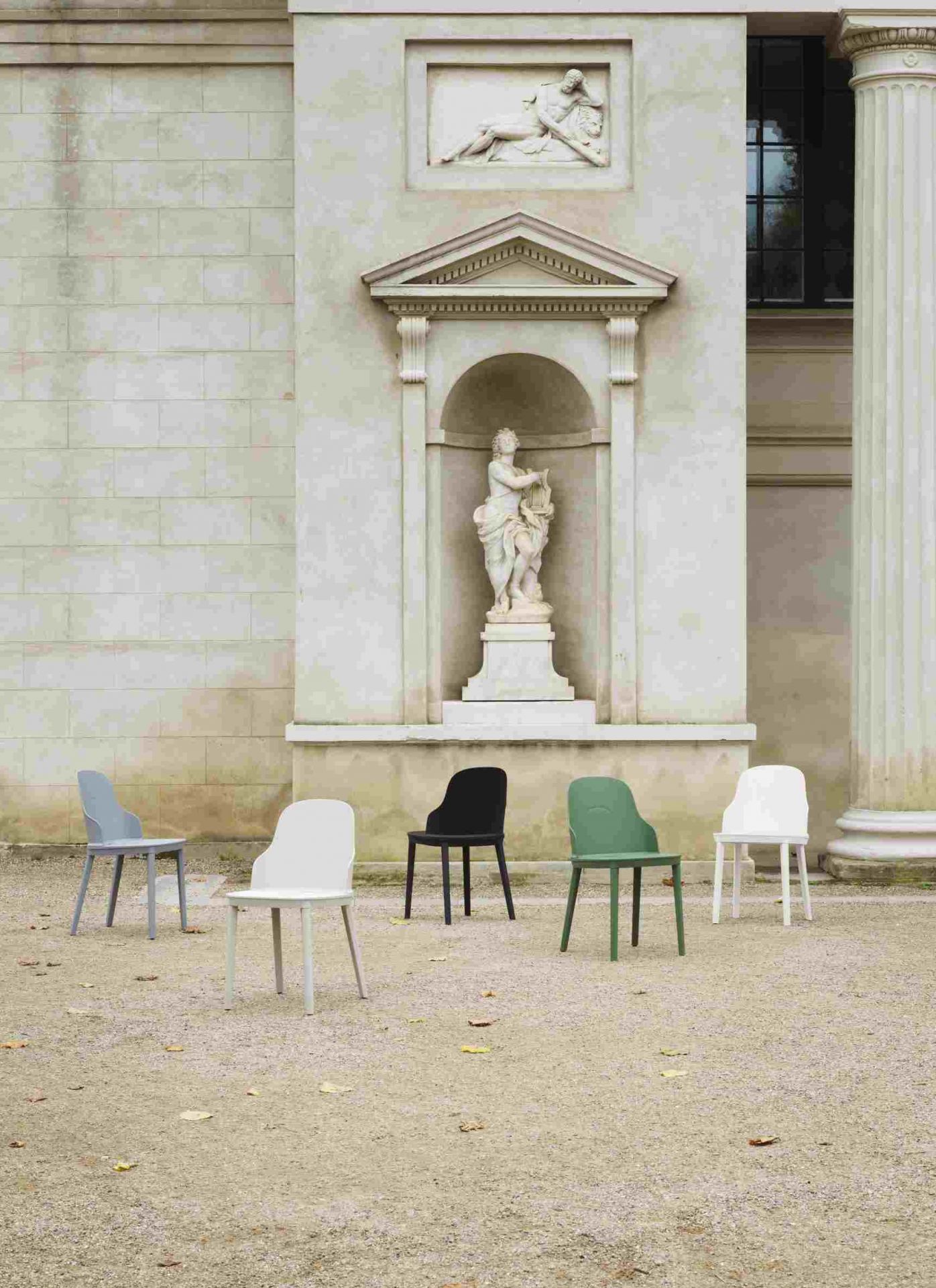 Fünf Allez Stühle von Normann Copenhagen in verschiedenen Farben vor einem Gebäude mit Statue.
