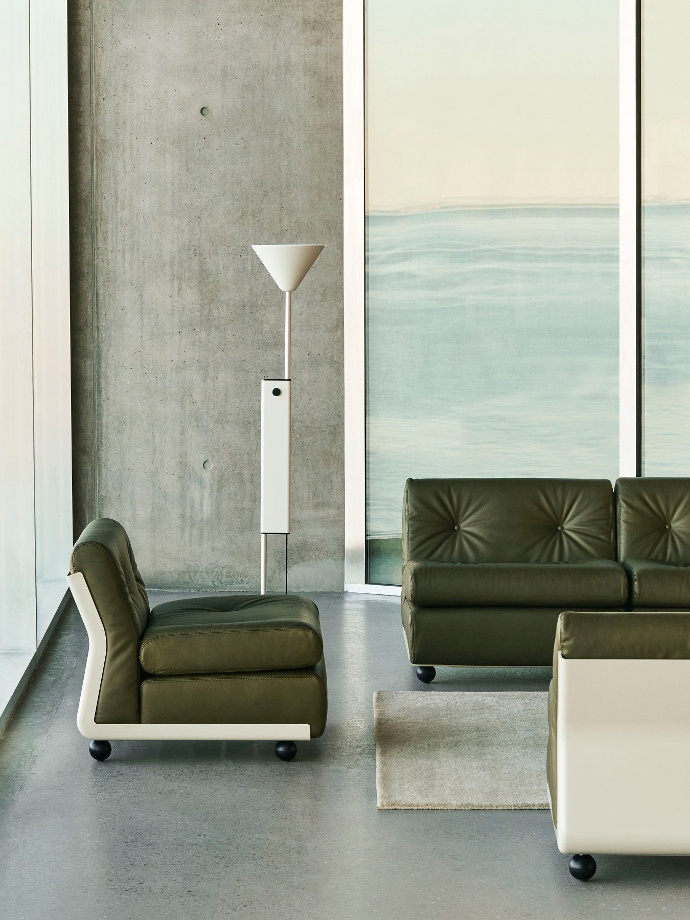 Hay Twist Floor Lamp Stehleuchte in modernem Wohnzimmer mit grünen Ledersofas und Meerblick.