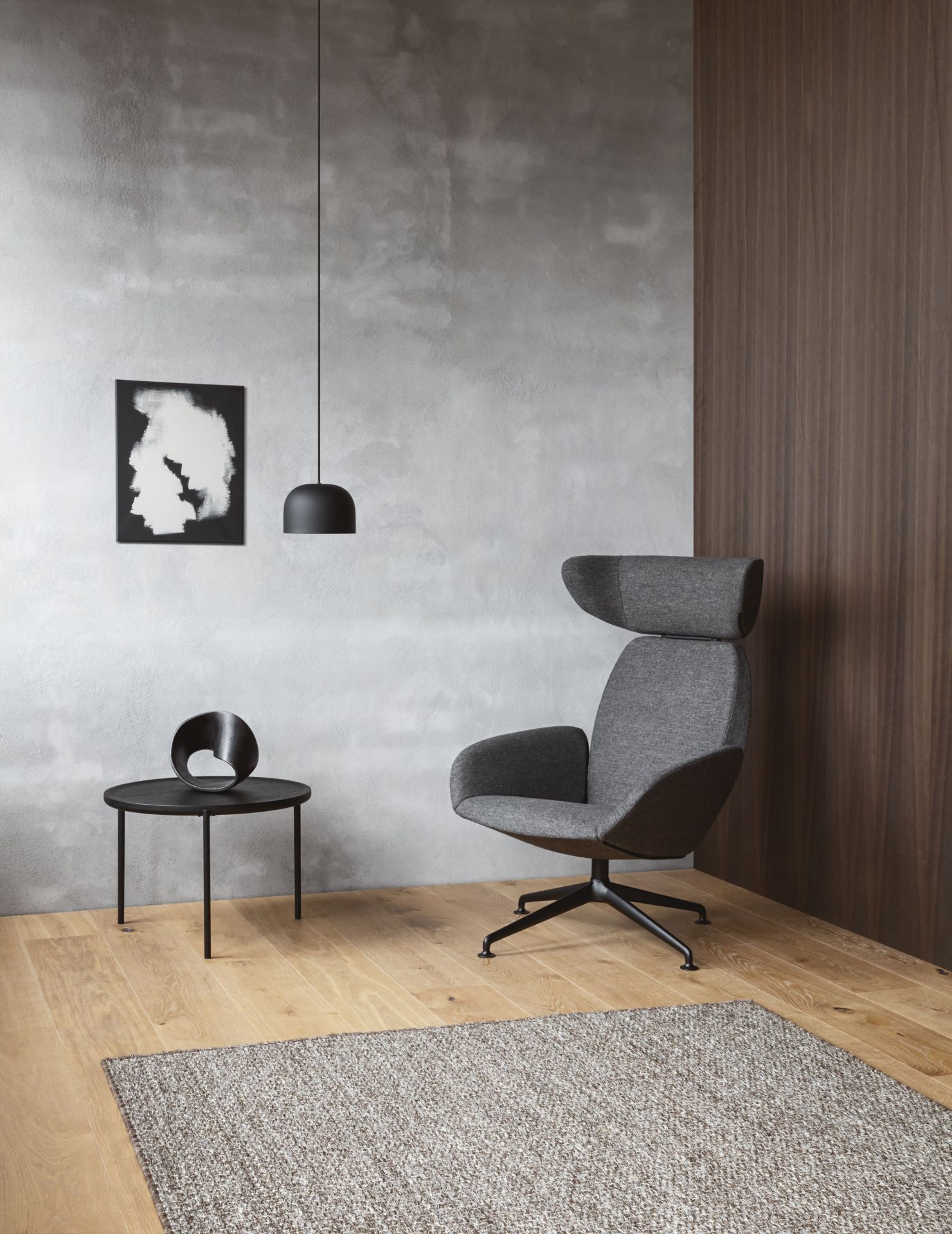 Grauer Laze Sessel von Eva Solo mit hoher Rückenlehne, schwarzem Fußkreuz und modernem Design.