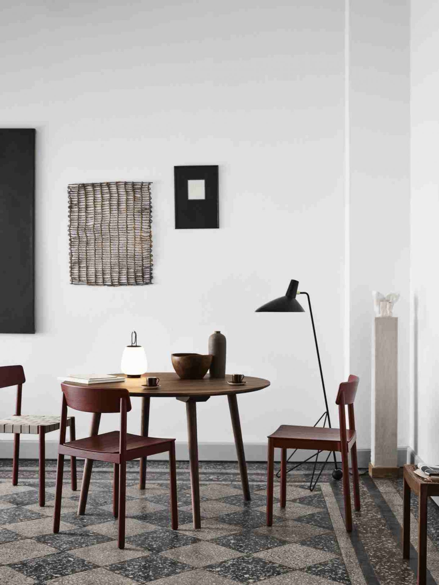 AndTradition In Between Table SK3 mit Holzstühlen in einem minimalistischen Esszimmer-Interieur.