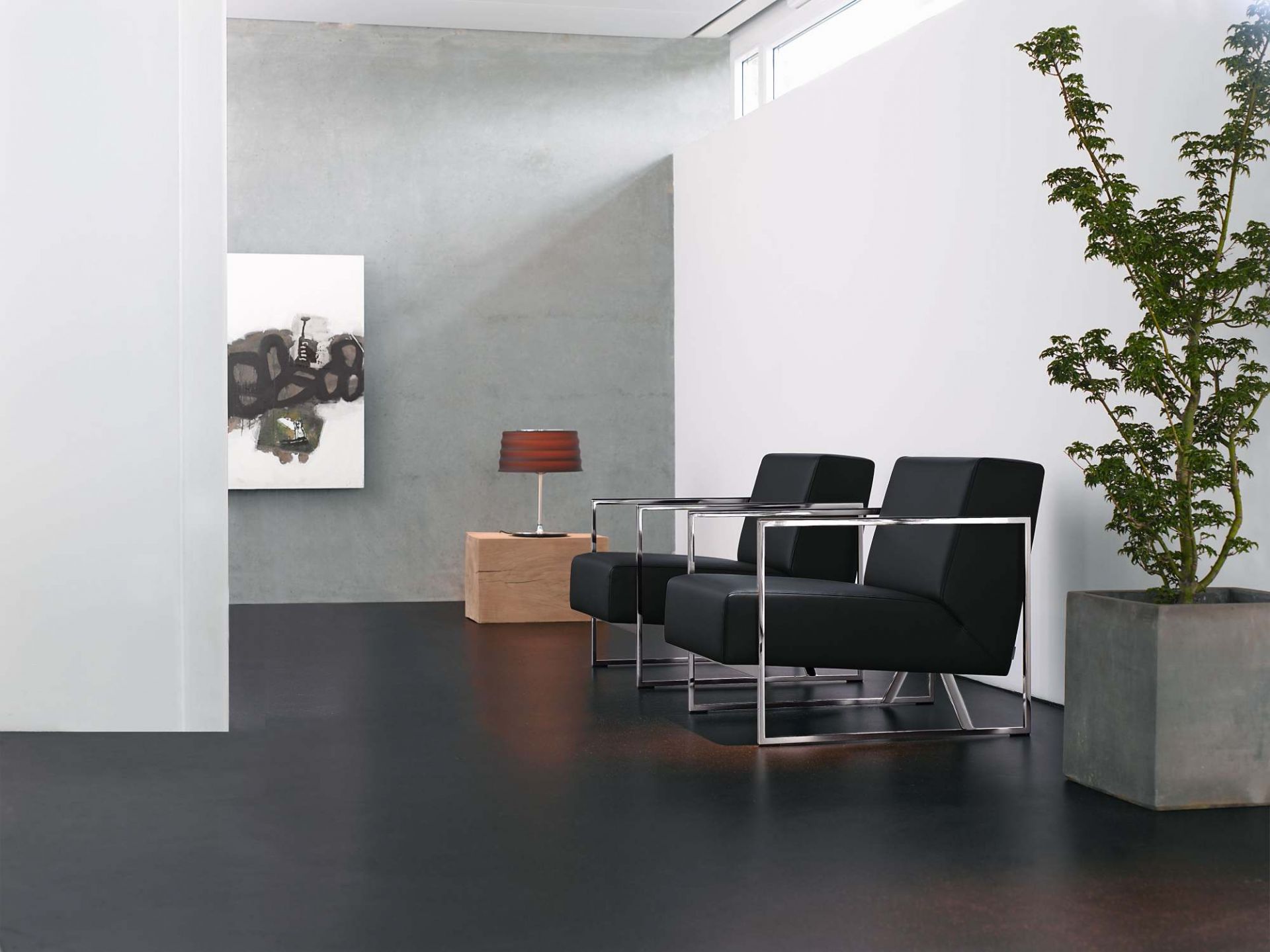 Zwei schwarze 610 Sen Sessel von Walter Knoll mit Chromgestell in modernem Interieur.