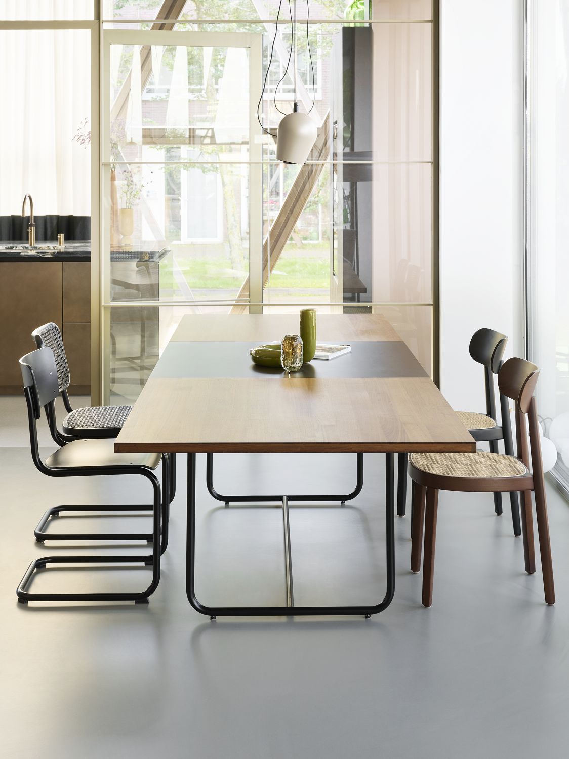 Esszimmer mit Holztisch und Thonet S 32 Freischwinger Stühlen mit Stahlrohrgestell.