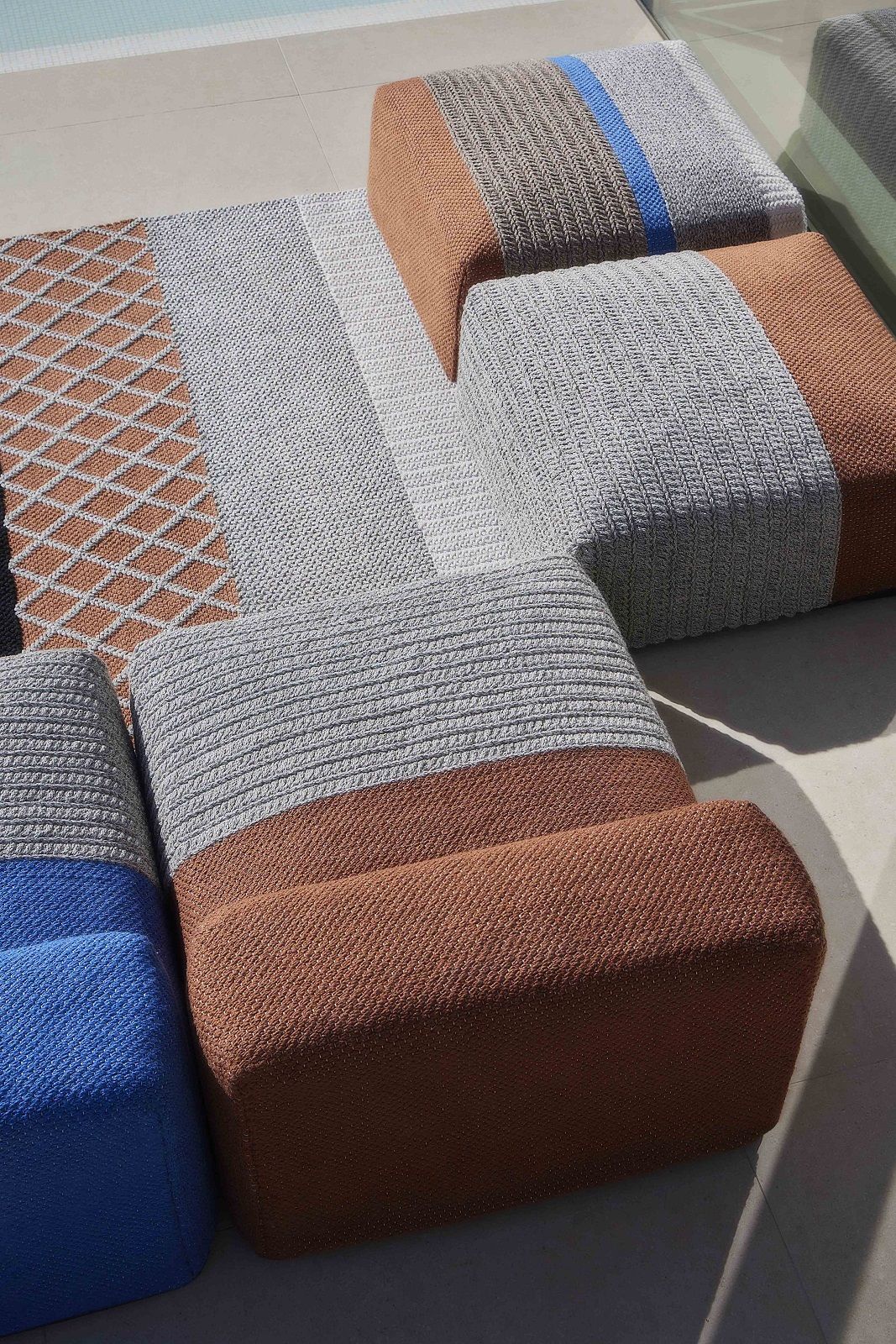 Detailaufnahme von modularen Outdoor-Sitzmöbeln der Mangas Kollektion in Grau, Braun und Blau, geeignet für Garten und Terrasse.