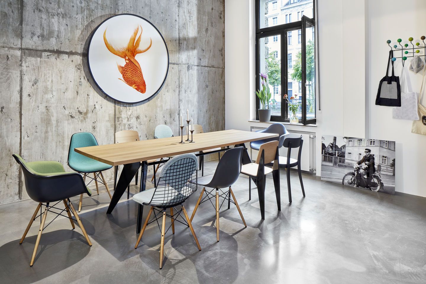 Esszimmer mit Holztisch und verschiedenen Eames Plastic Arm Chairs DAW Stühlen von Vitra.