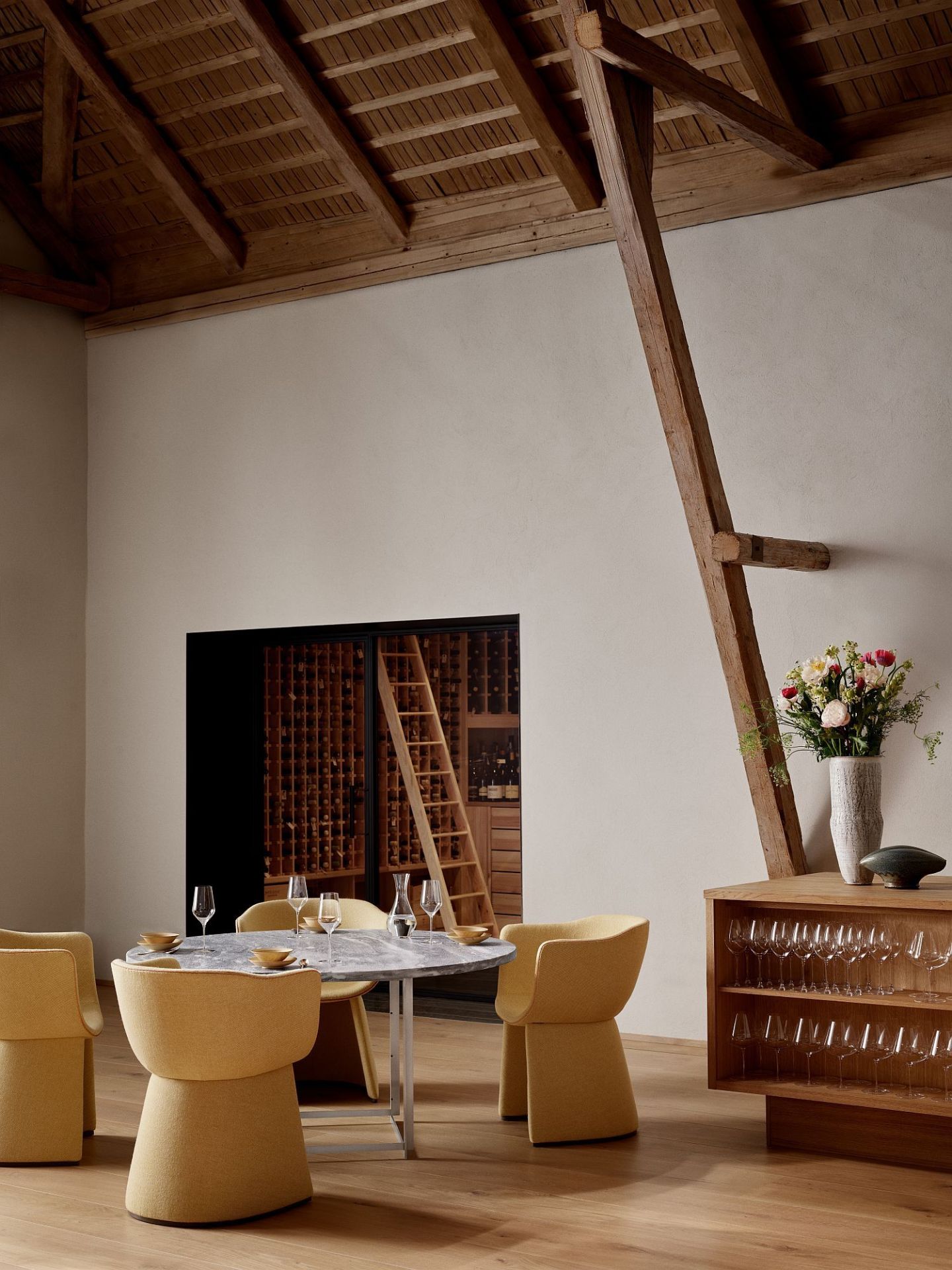 Gelber Monolit Esszimmerstuhl von Fritz Hansen an Marmortisch in modernem Interieur mit Weinkeller.