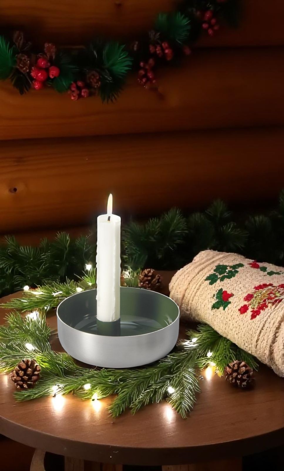 Biel 1er Kerzenschale von Philippi aus Stahl mit brennender Kerze und weihnachtlicher Dekoration auf einem Holztisch.