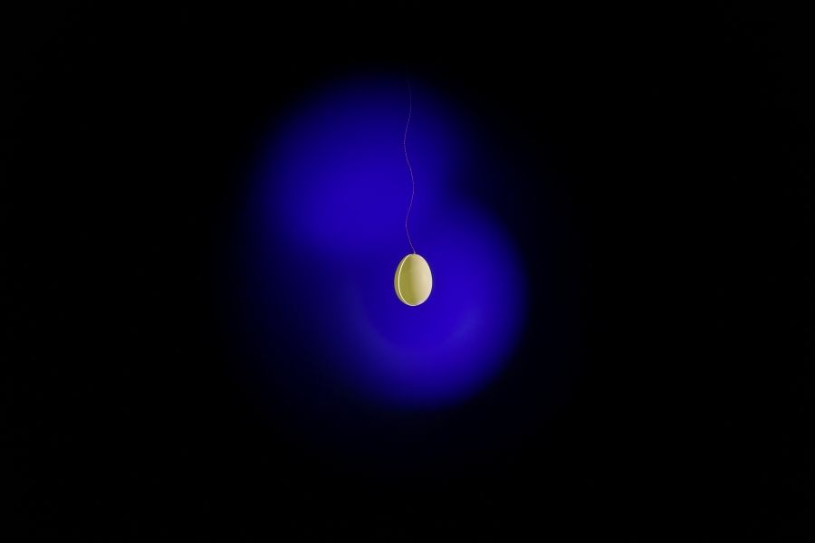Goldene Ingo Maurer Pendelleuchte mit blauem Lichteffekt. Design Lampe für Wohnzimmer und Esszimmer.