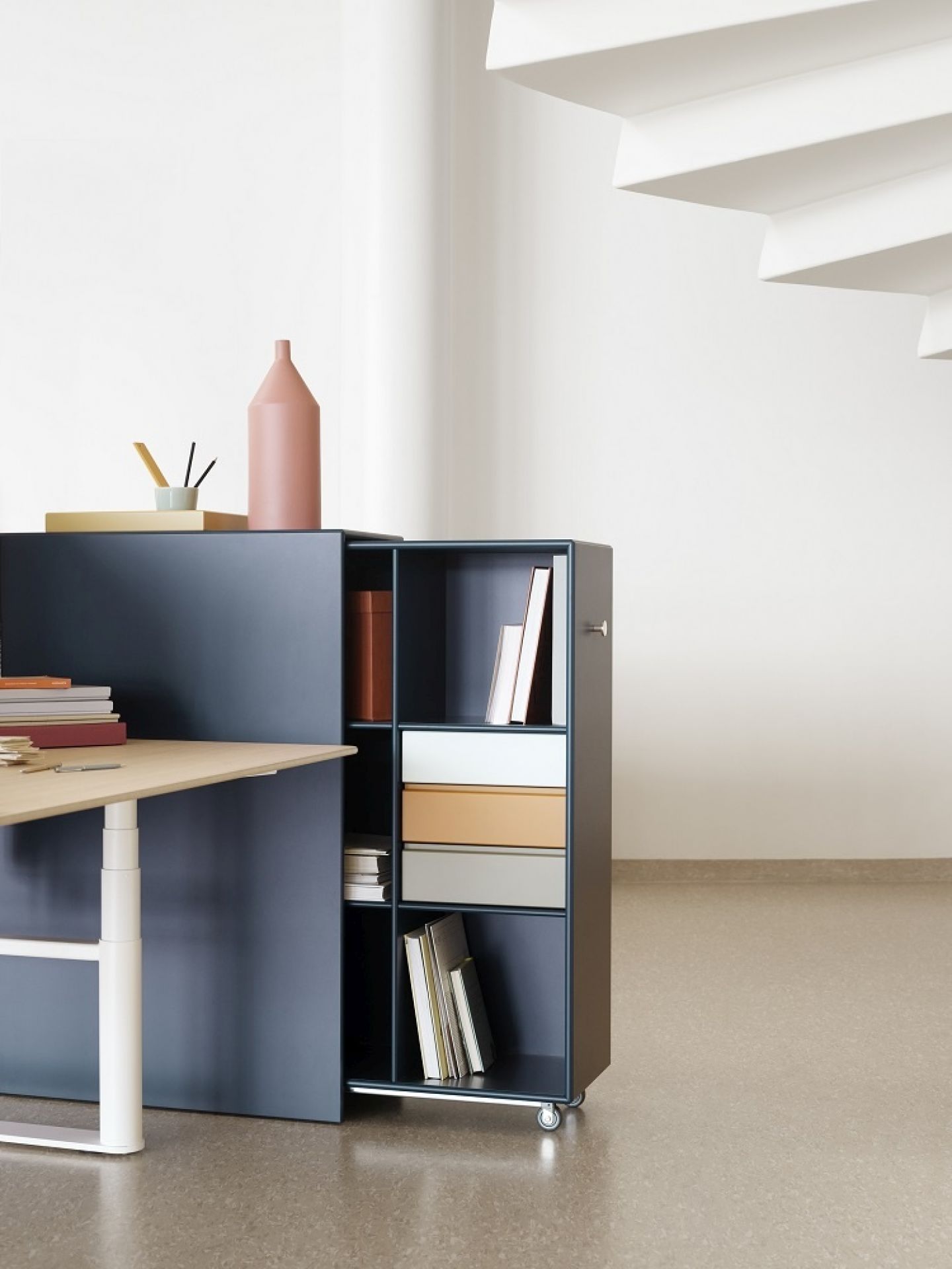 Montana Cargo Modul 80 Schrank-System in Blau mit Regalen, Schubladen und Rollen, kombiniert mit Schreibtisch.