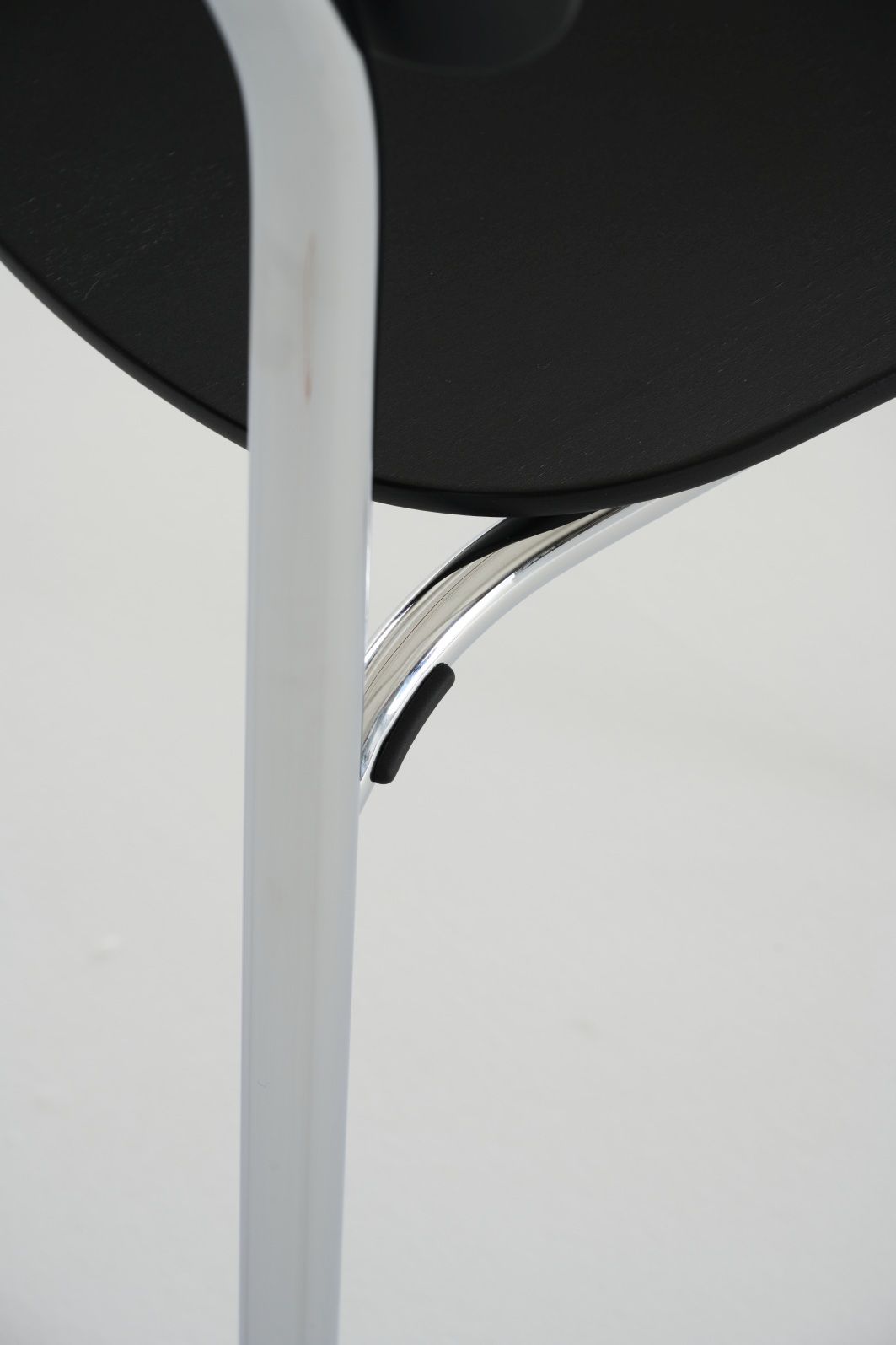 Detailaufnahme des Thonet S 243 Stahlrohrstuhls mit schwarzer Sitzfläche und verchromtem Gestell, ein Designklassiker.
