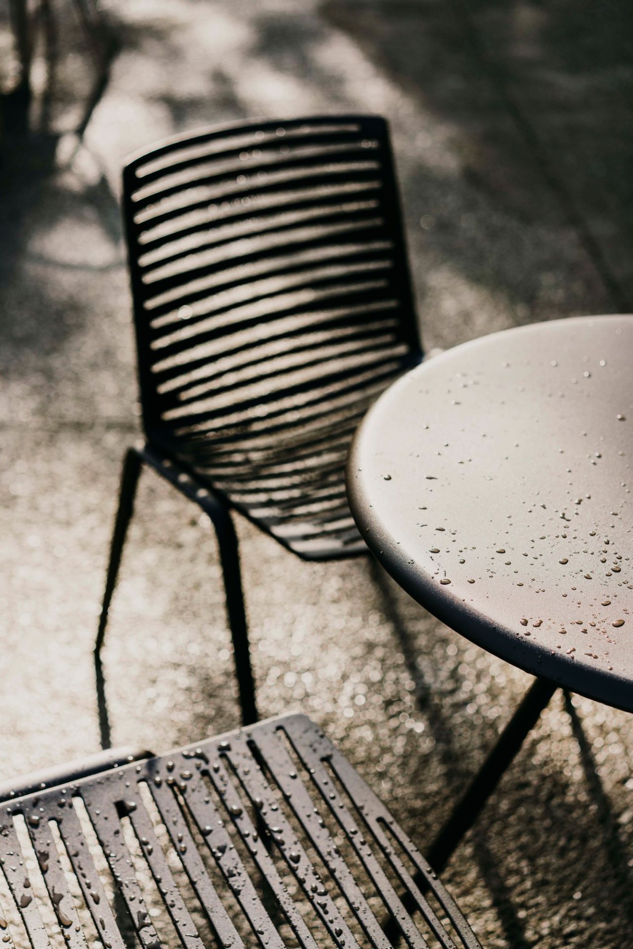 Zwei Zebra Gartenstühle und ein Tisch mit Wassertropfen, moderne Outdoor Sitzmöbel für Terrasse.