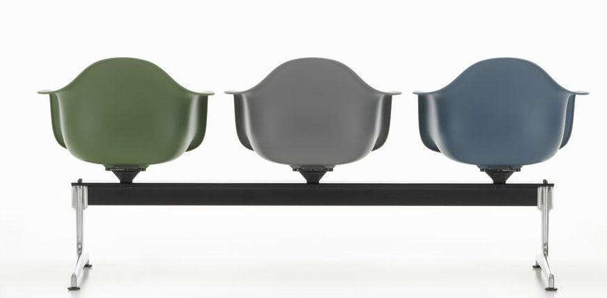 Vitra Eames Plastic Armchair RE auf Traverse, drei farbige Sitzschalen auf schwarzem Gestell.