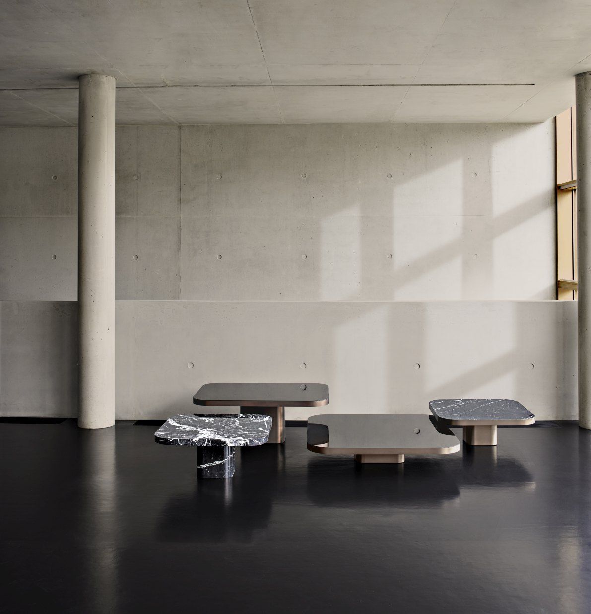 ClassiCon Bow Coffee Table No.1: Vier moderne Couchtische mit Marmor- und Glasplatten in minimalistischem Raum.