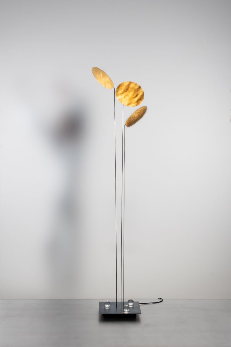 Nuunu Stehleuchte von Ingo Maurer: Moderne Stehlampe mit goldenen, runden Lampenschirmen und filigranem Design.