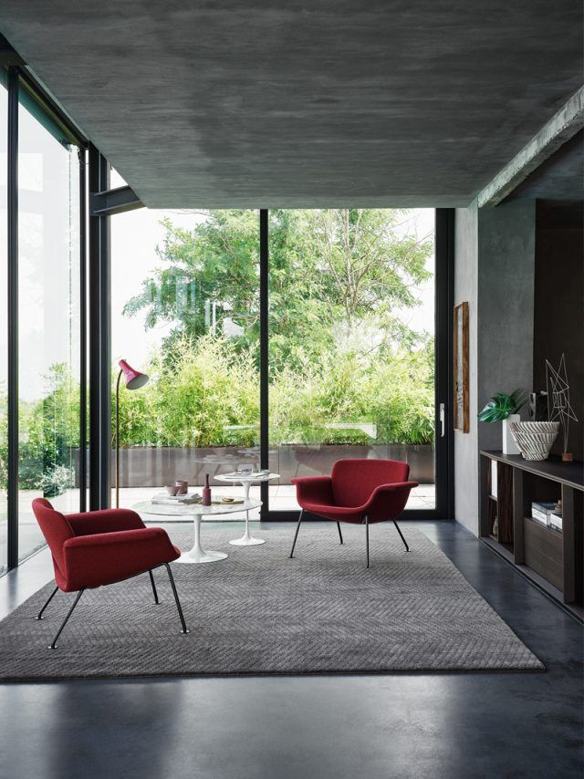 Zwei rote KN04 Stühle von Knoll International in modernem Wohnzimmer mit Teppich.