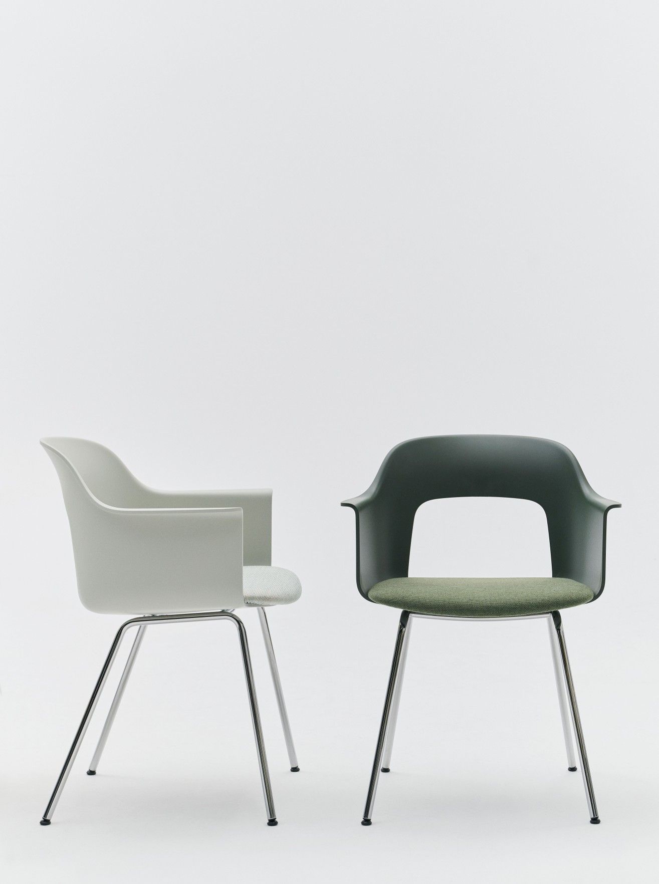 Zwei Hay Layout Armchair 213 Armlehnstühle in Grau und Grün mit Chromgestell vor weißem Hintergrund.