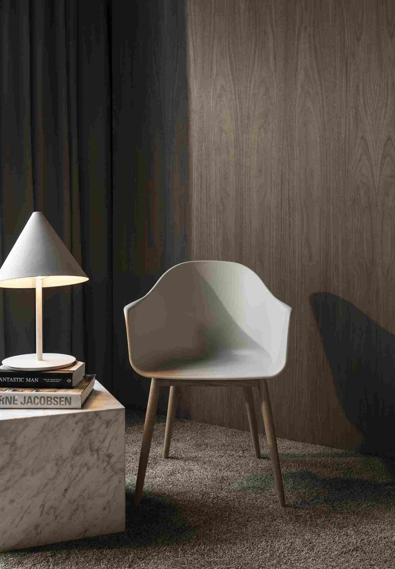 Audo Copenhagen Stuhl in Weiß mit Holzbeinen neben einem Marmor-Tisch mit Lampe.