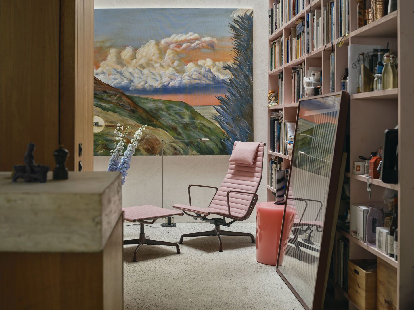 Rosa Vitra Aluminium Chair EA 125 mit Hocker in stilvollem Interieur, Designklassiker für Wohnzimmer und Büro.