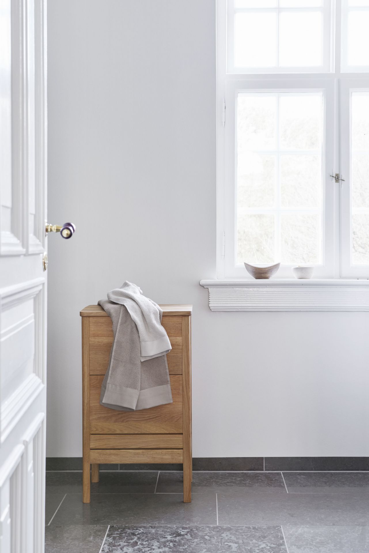 A Line Waschtisch Eiche weiß geölt von Form & Refine mit Handtuch im Badezimmer.