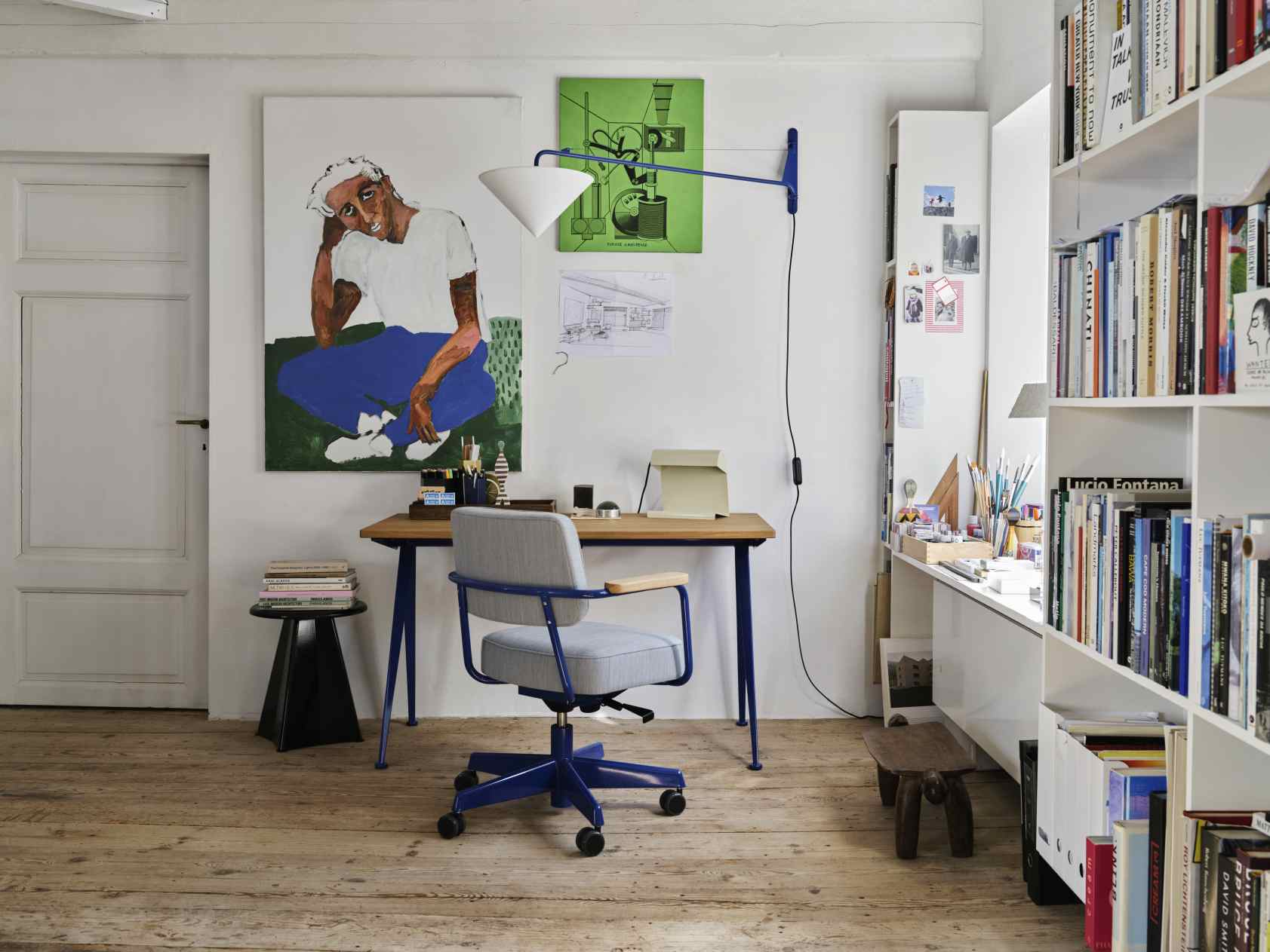 Detailaufnahme eines Arbeitszimmers mit Vitra Bürostuhl und Tabouret Métallique Hocker in modernem Ambiente.