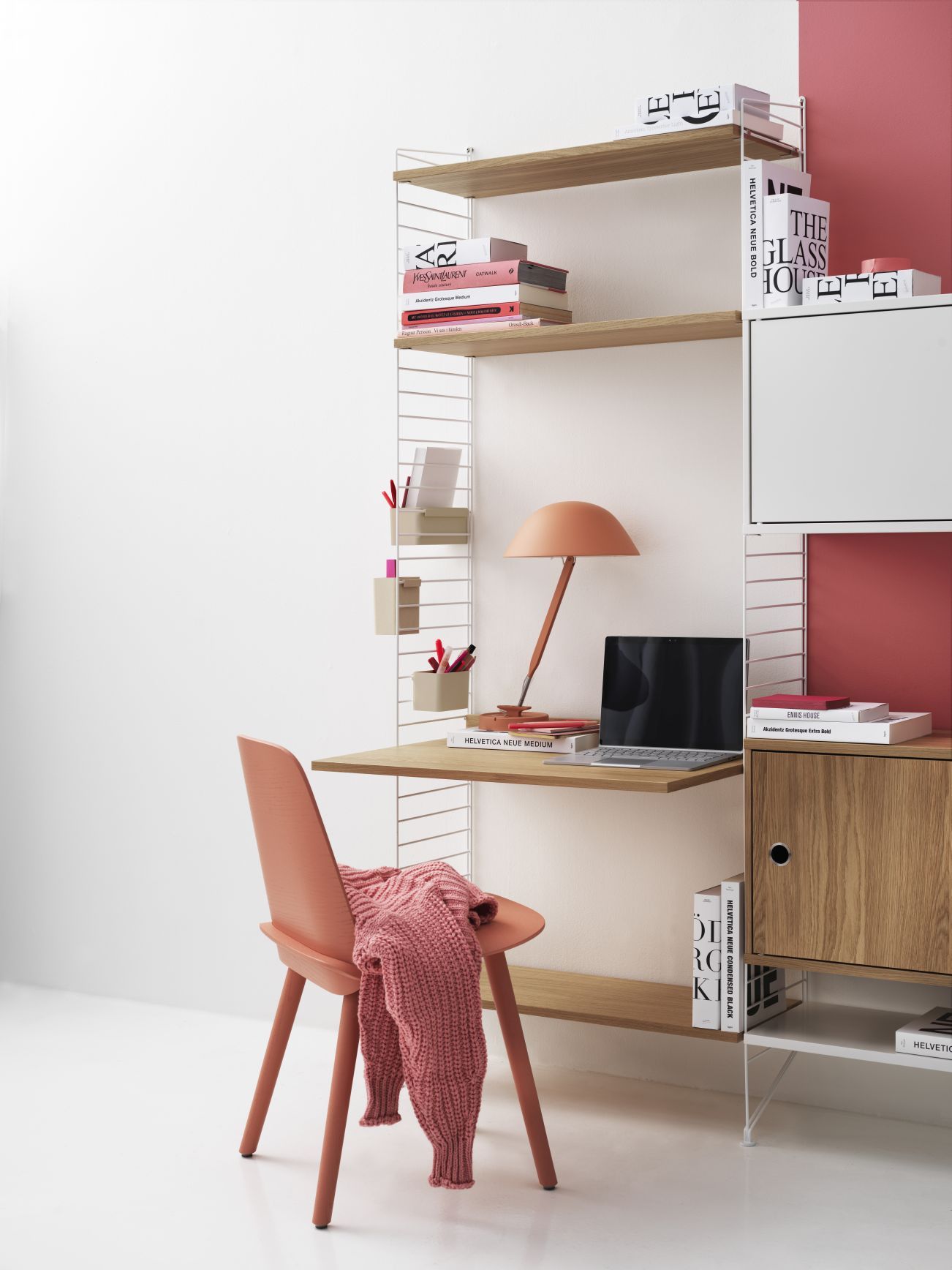 Beige String Regalsystem an der Wand mit Schreibtisch, Lampe, Laptop und Stuhl.