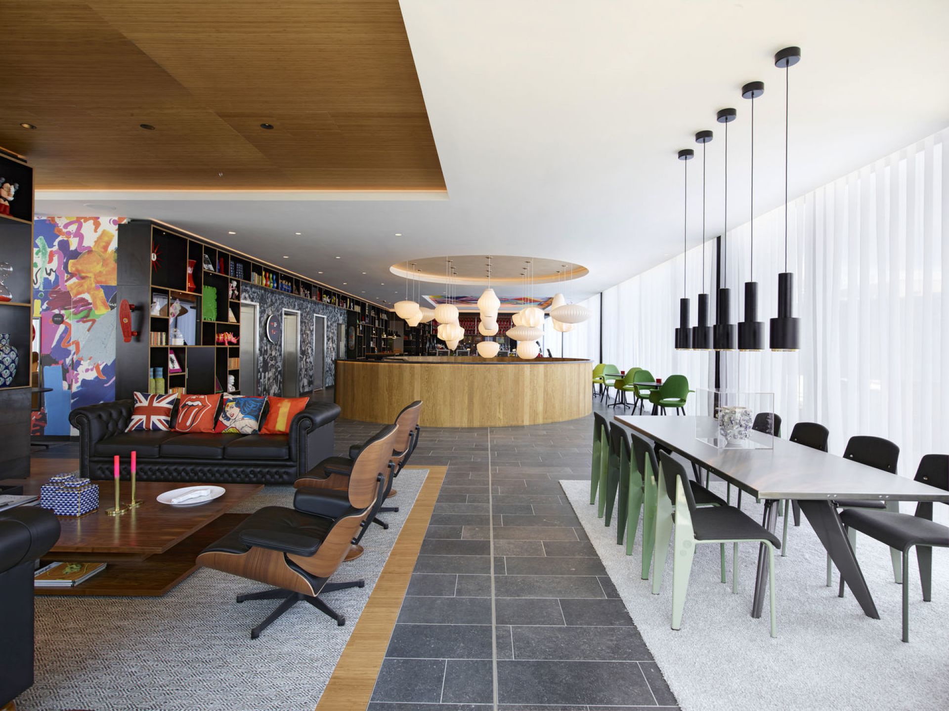 Innenaufnahme eines modern eingerichteten Raumes mit Vitra Stühlen, Sofas, Esstisch und dekorativen Elementen.