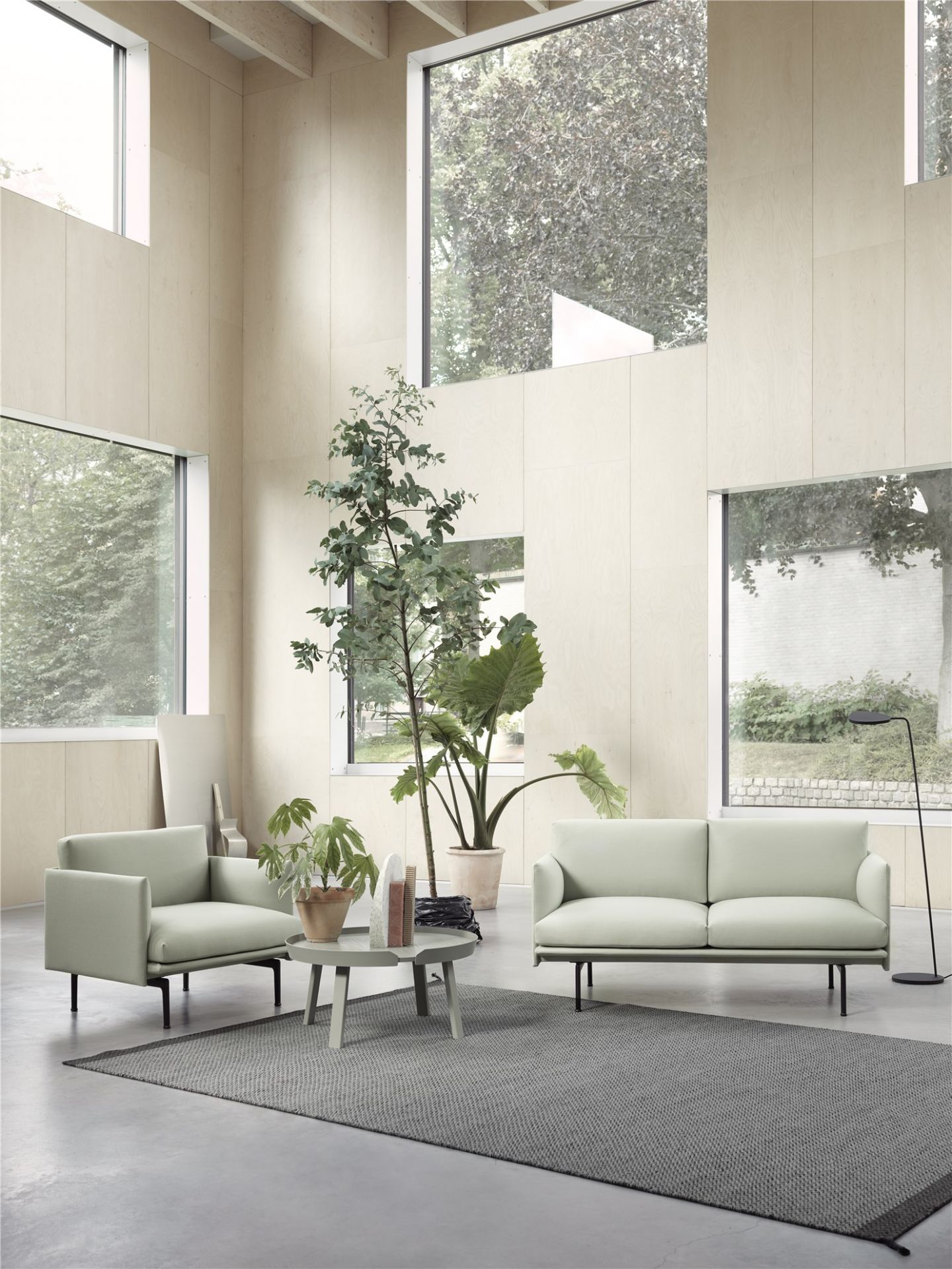 Heller Raum mit Muuto Outline Chair Sessel und Sofa in Pastellgrün.
