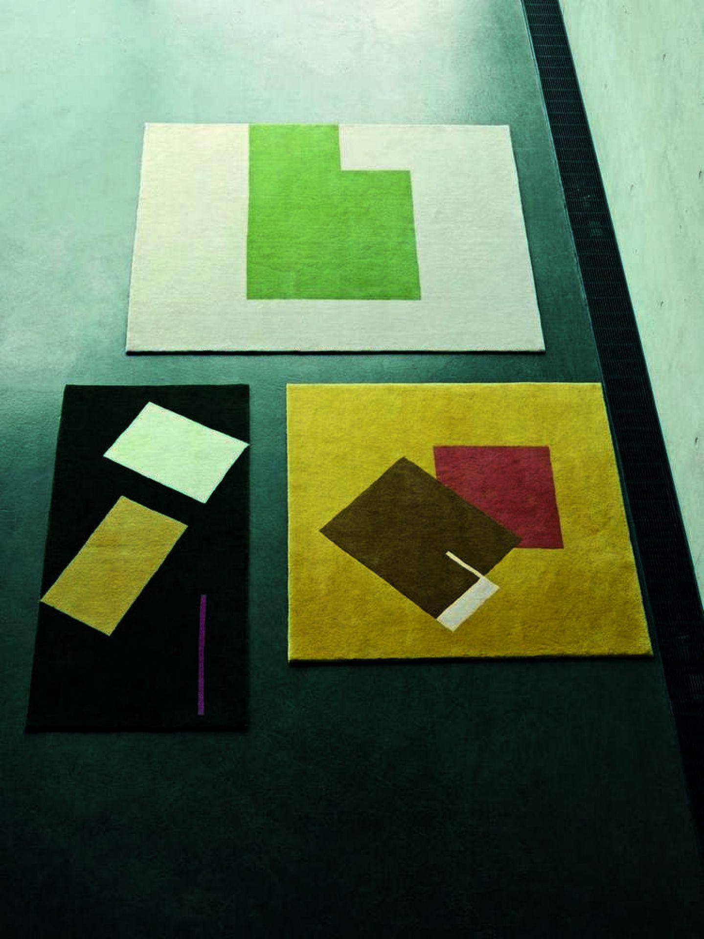 Drei ClassiCon Teppiche mit geometrischen Mustern in Grün, Gelb und Schwarz. Moderne Teppich-Designs.