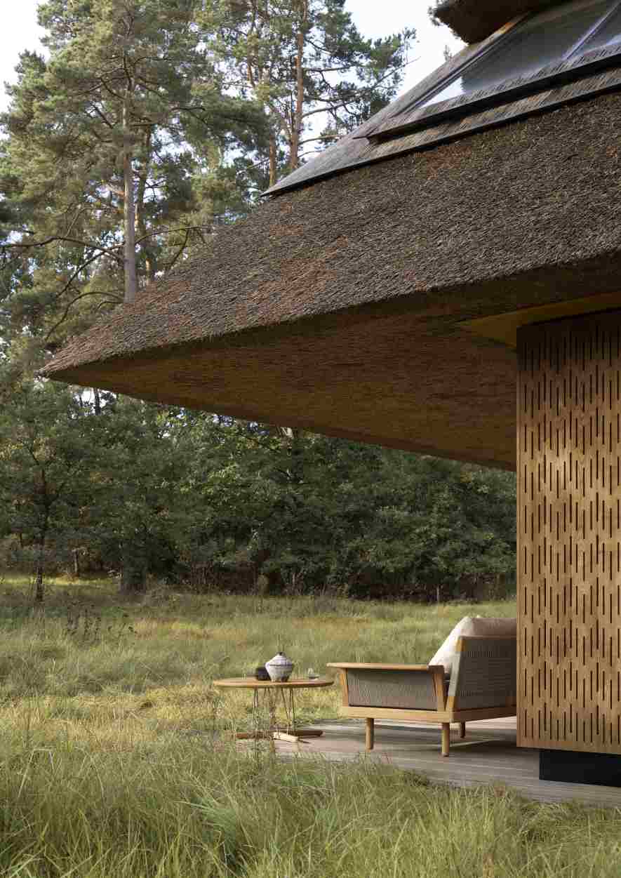 E023 Embrace Lounge Tisch von Carl Hansen & Søn im Outdoor-Bereich mit Strohdach-Hütte.