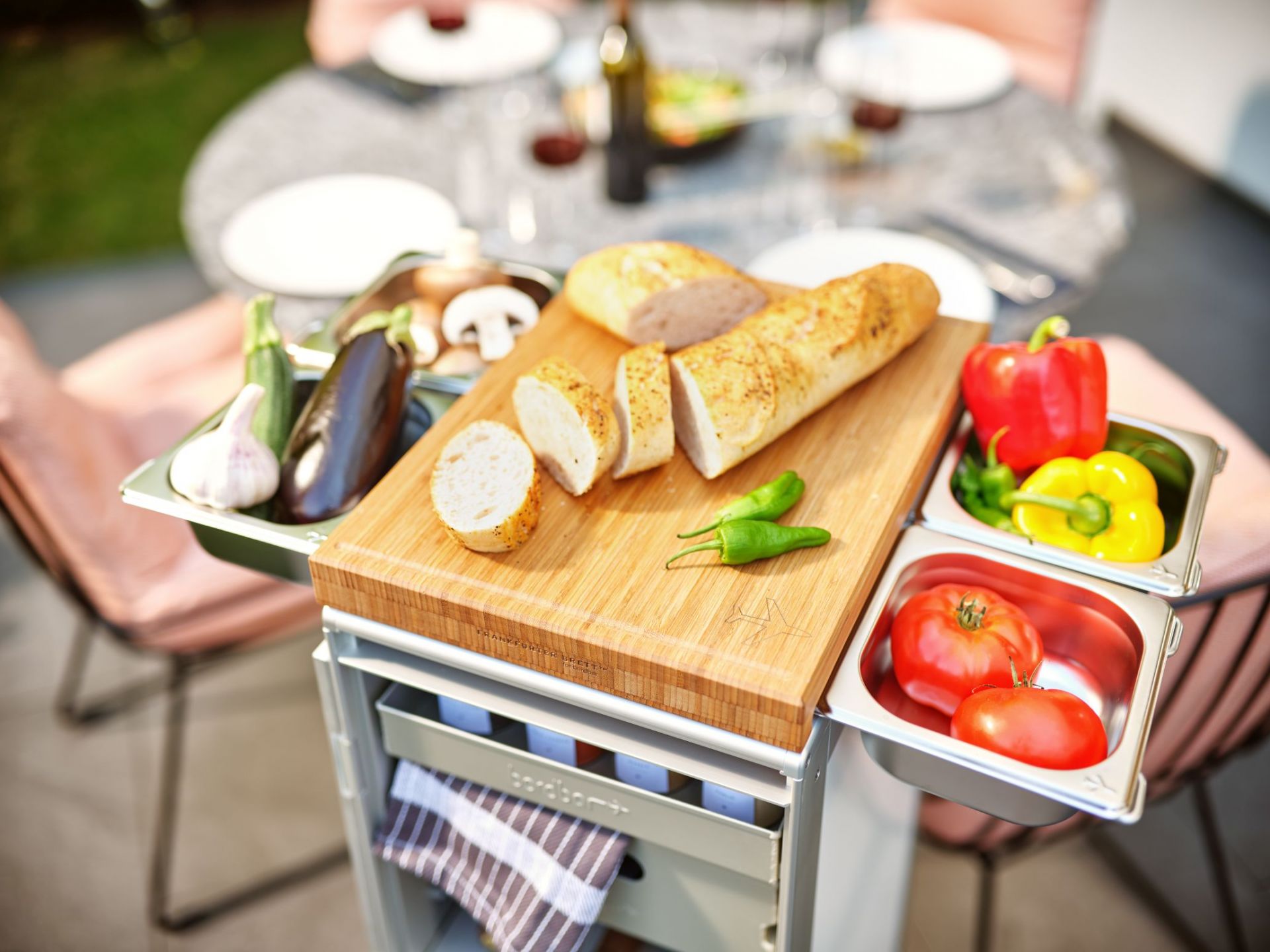 Bordbar Servierwagen Zubehör Set mit Schneidebrett, Gemüse und Brot für die Zubereitung.